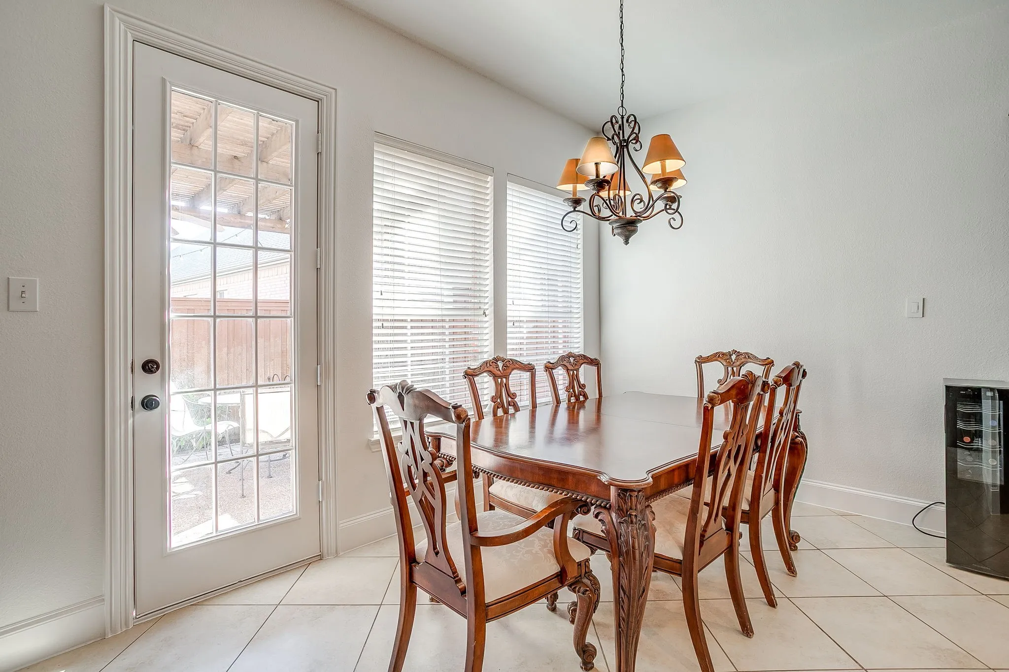 Dining room featuring a chandelier, light tile patterned flooring, and beverage cooler