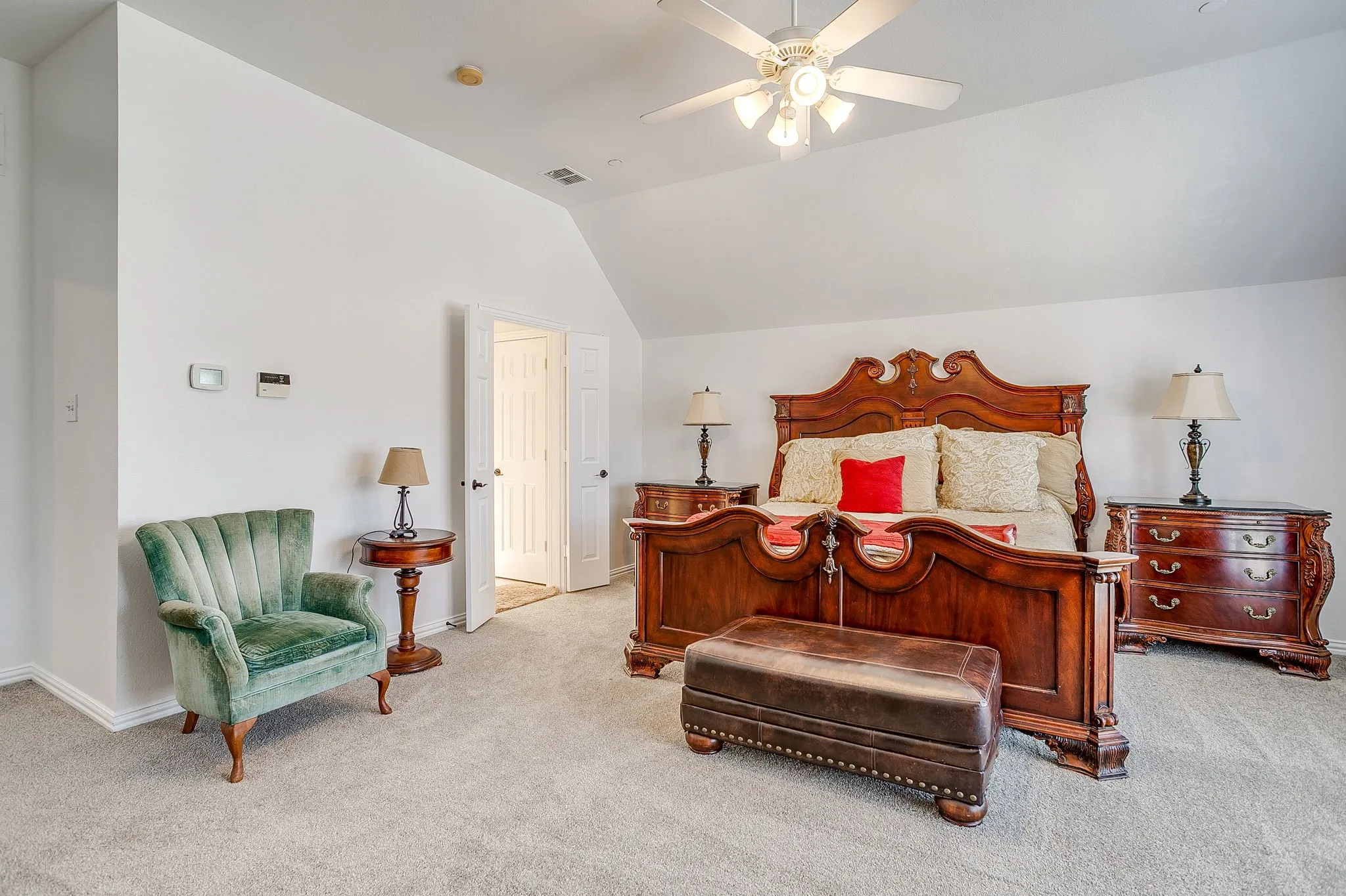 Bedroom featuring light carpet, vaulted ceiling, and ceiling fan