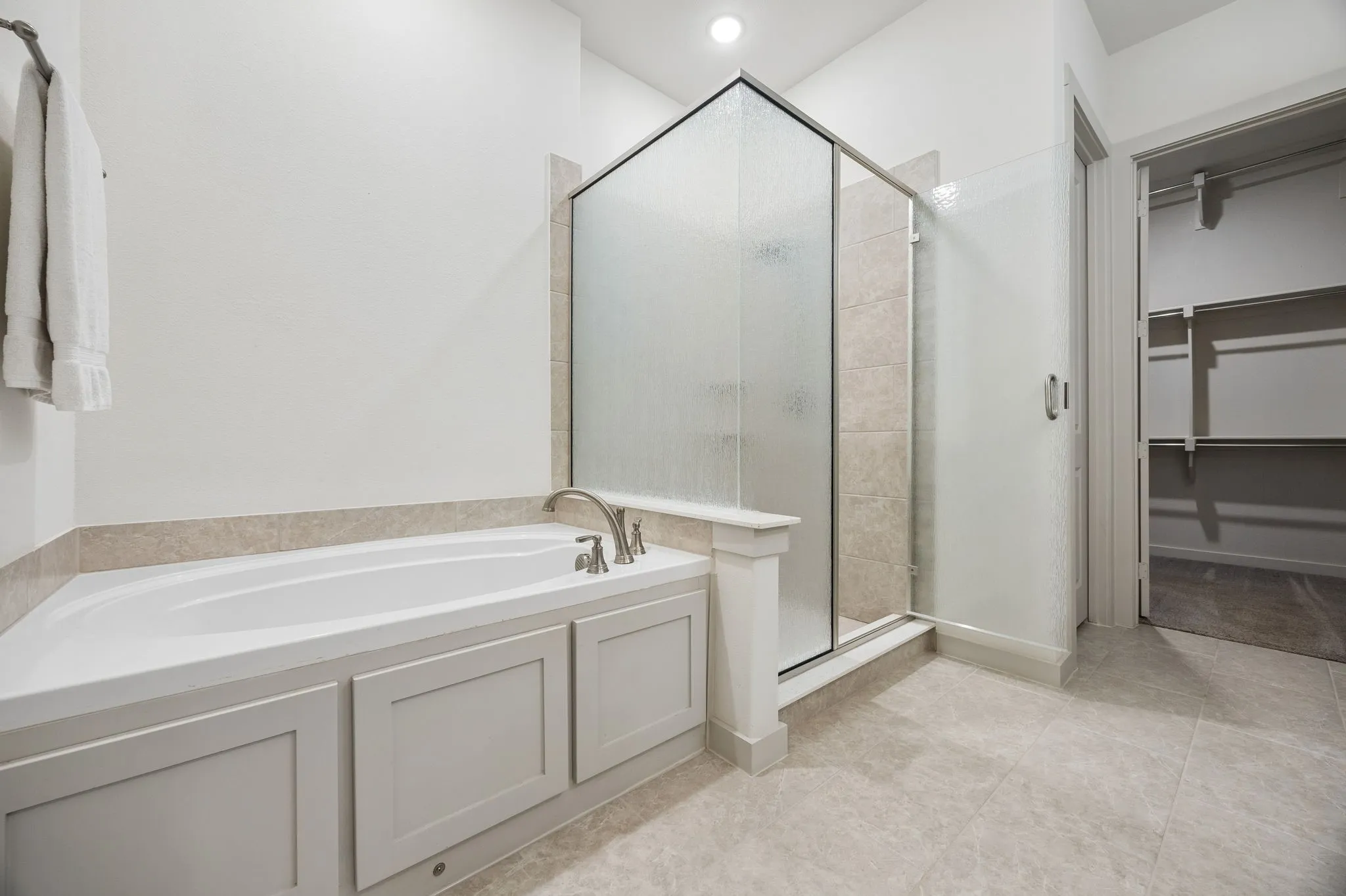 Primary ensuite is a spa-like bathroom with a soaking tub, dual vanities, and a beautifully designed walk-in closet.