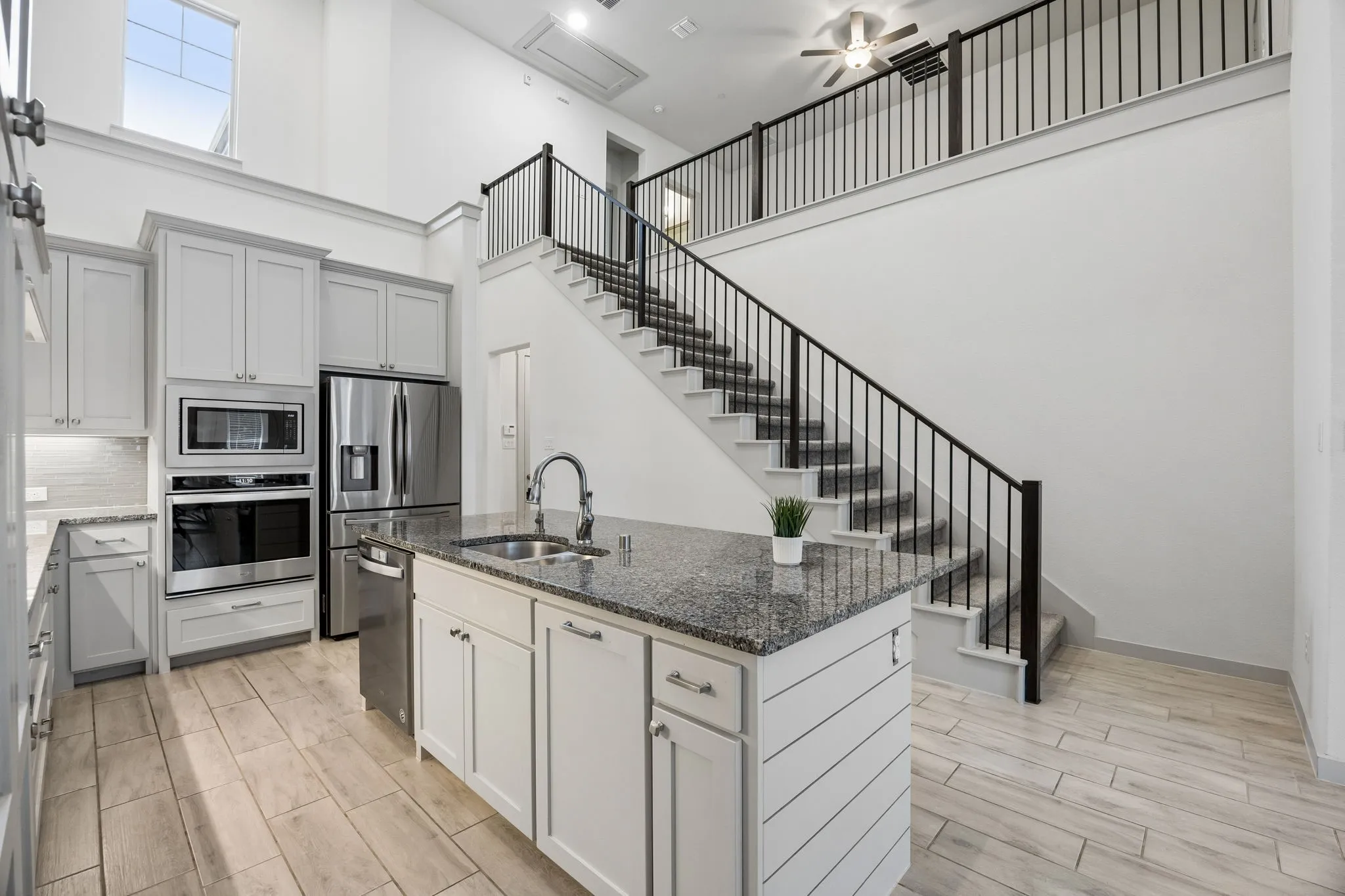 Kitchen includes built in microwave, double sink, gas cooktop, 2 story ceiling with natural light.