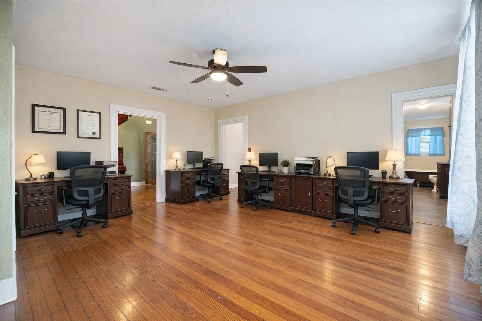 Spacious interior featuring wood-finish flooring, a ceiling fan, and multiple archways
