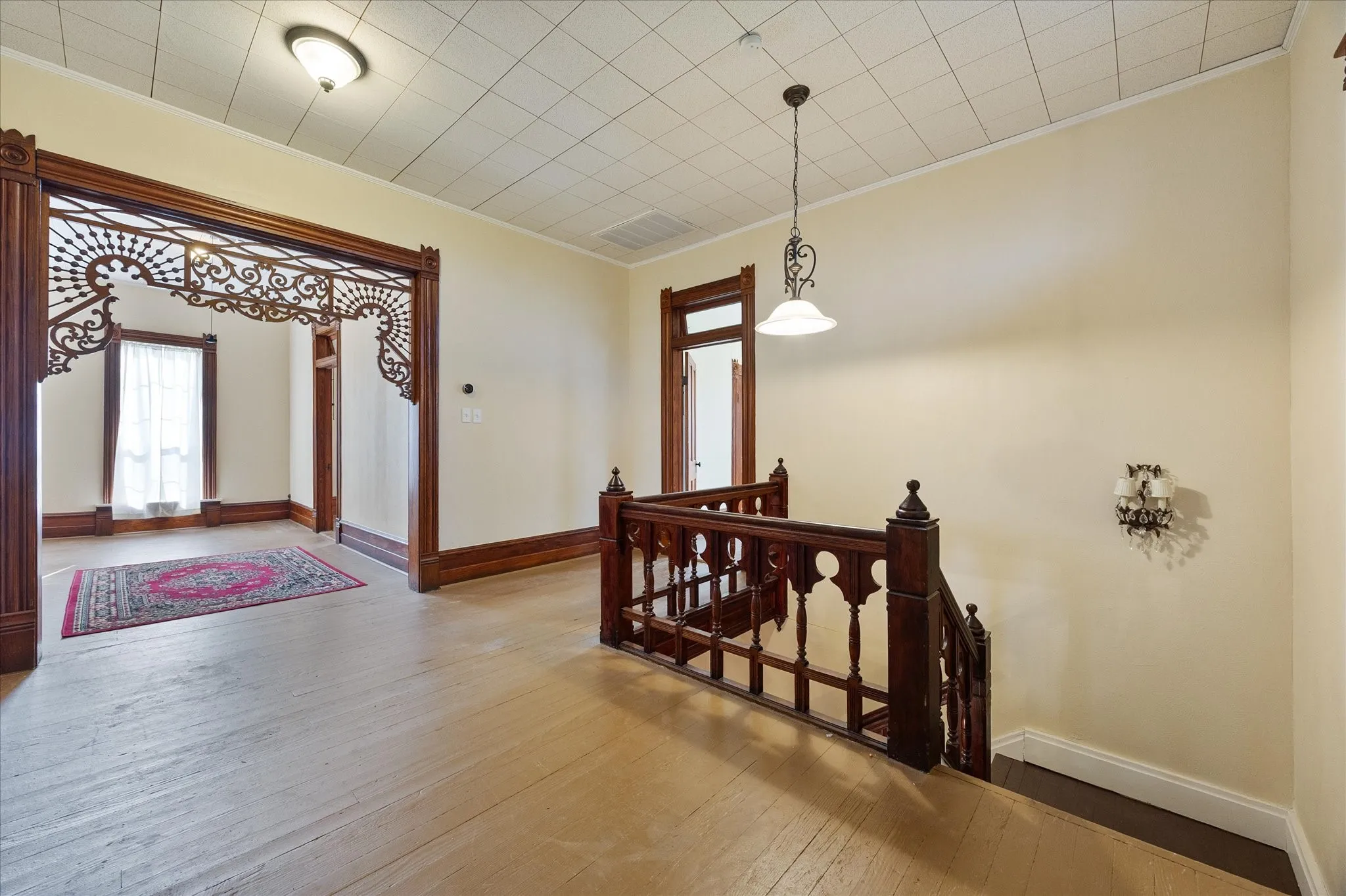 Hardwood flooring throughout featuring an ornate wood archway with decorative detailing