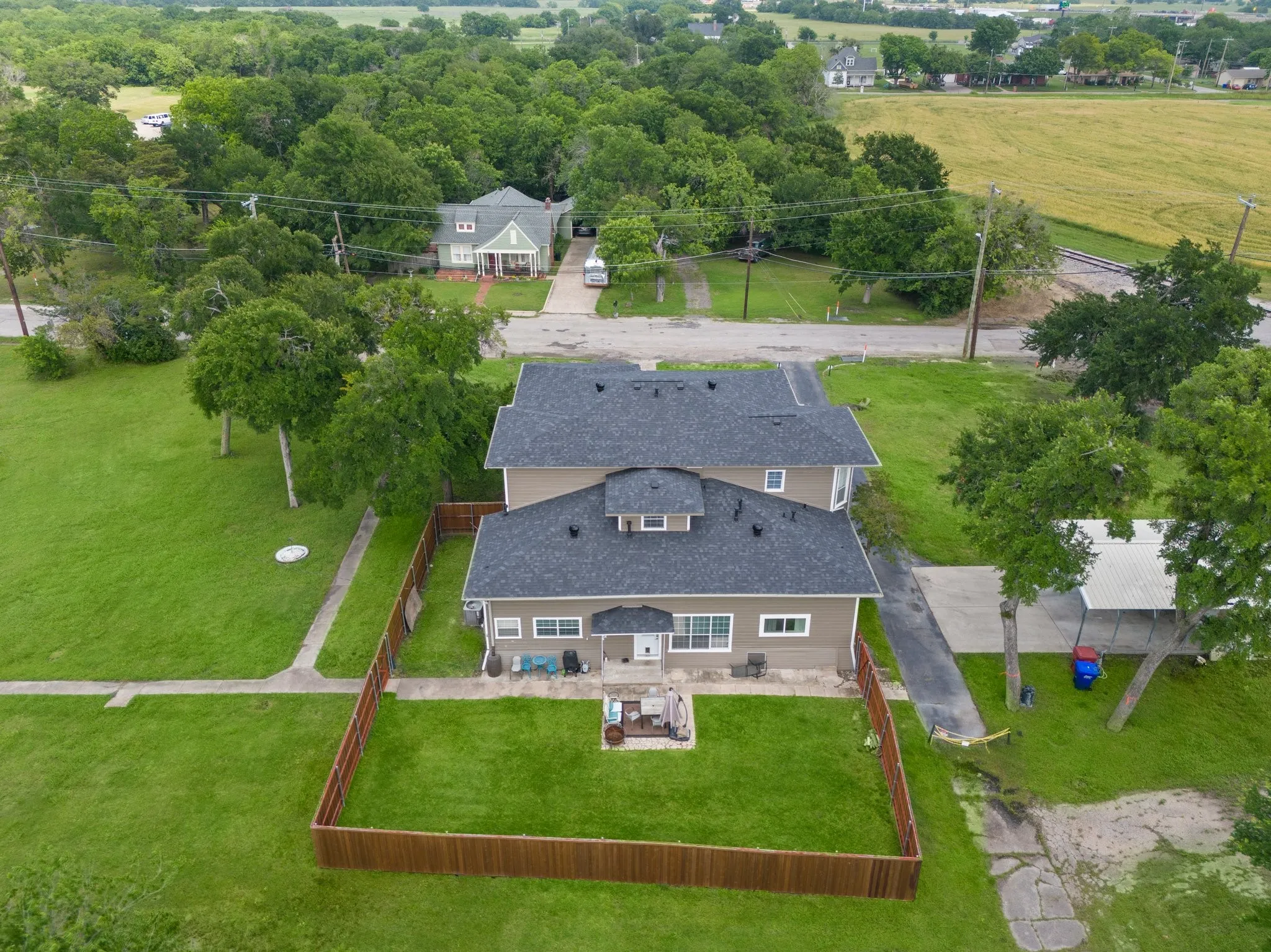 Exterior property featuring a pitched roof, neutral-toned siding, and a fenced backyard