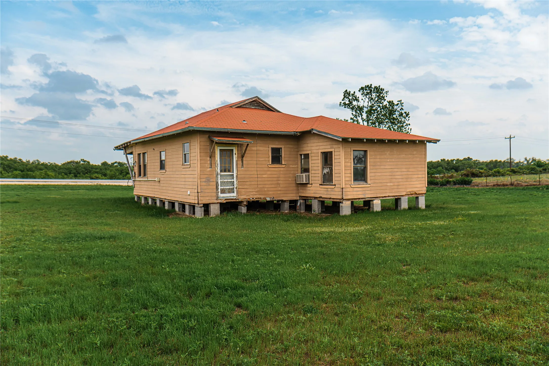 Single-story structure featuring horizontal wood siding and an orange roof