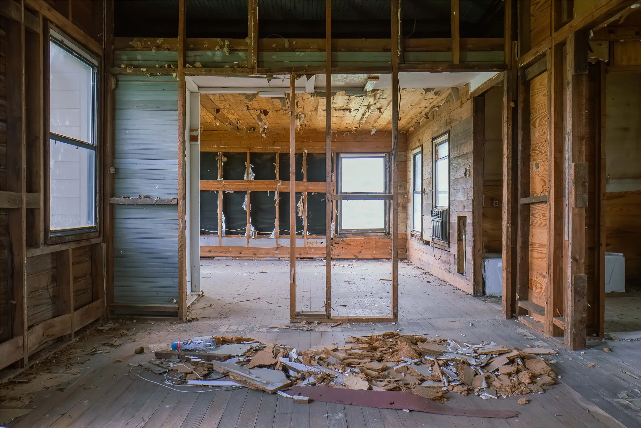 Exposed timber framing revealing structural elements, with multiple window openings providing natural light