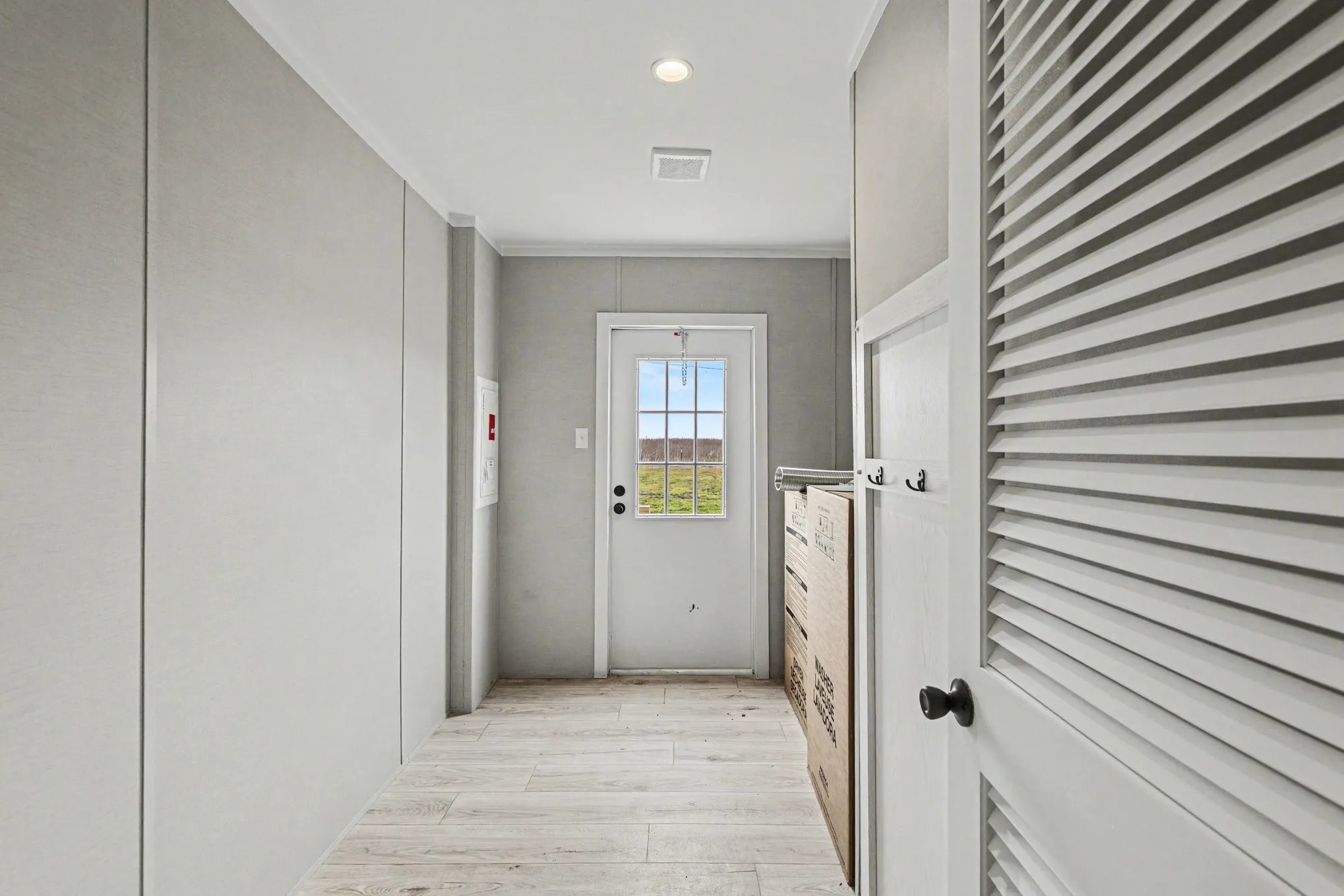 Laundry featuring room for full-sized washer and dryer and a white windowed door for additional natural light that leads to backyard. The washer and dryer still in original boxes for the photo.