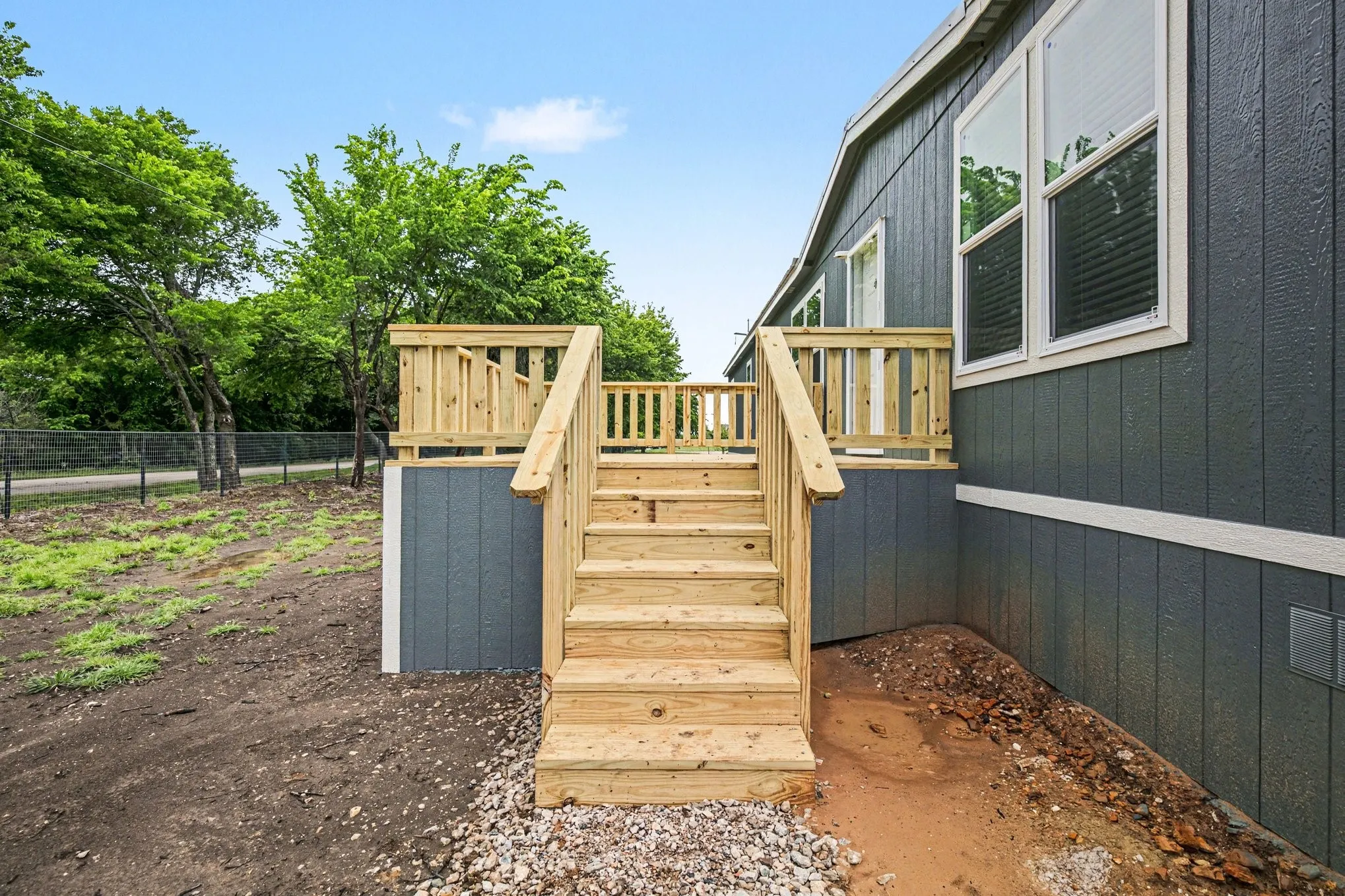 Newly constructed wooden deck with stairs providing exterior access