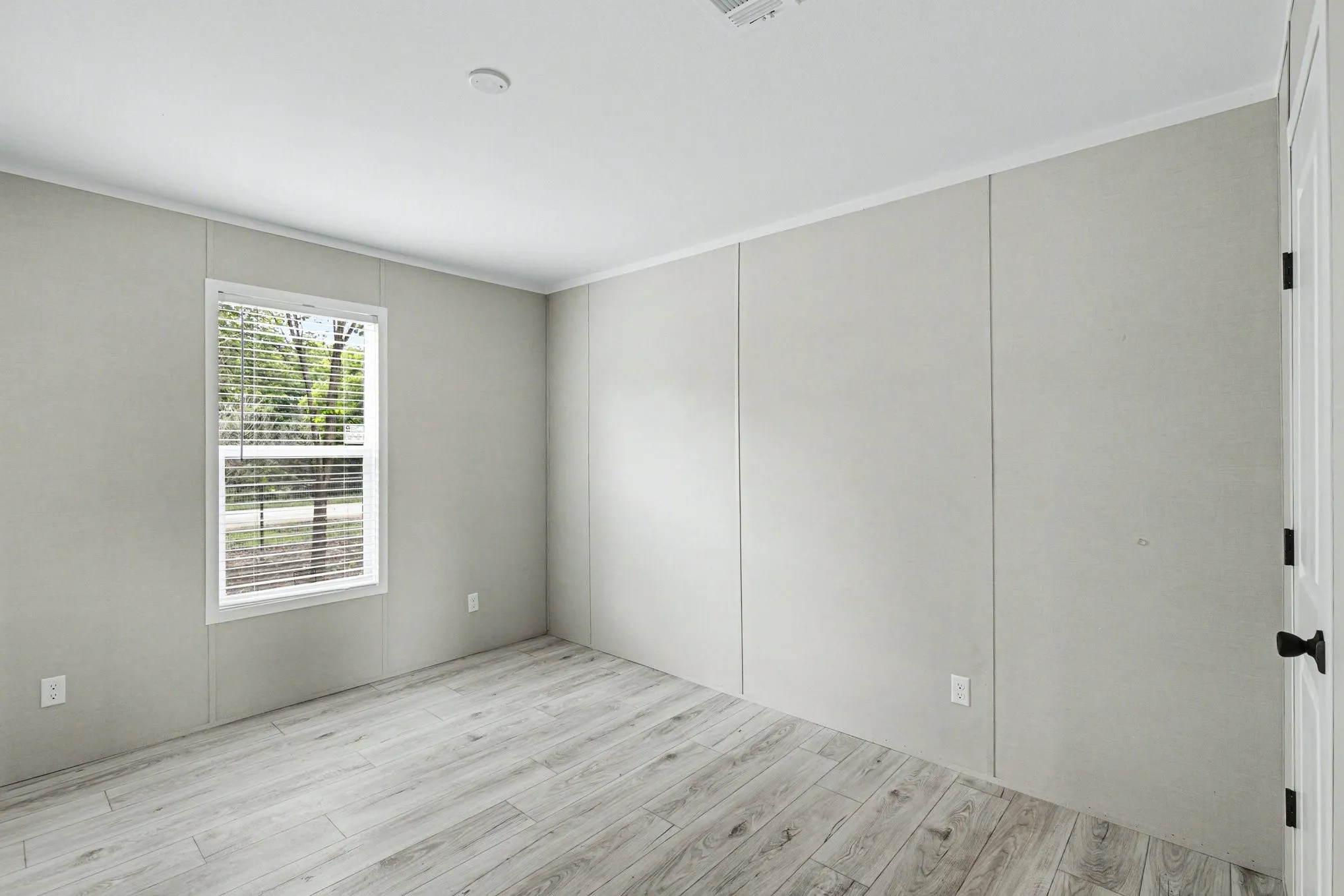 Bright interior featuring wood-look flooring, a cloet, and a single window with blinds