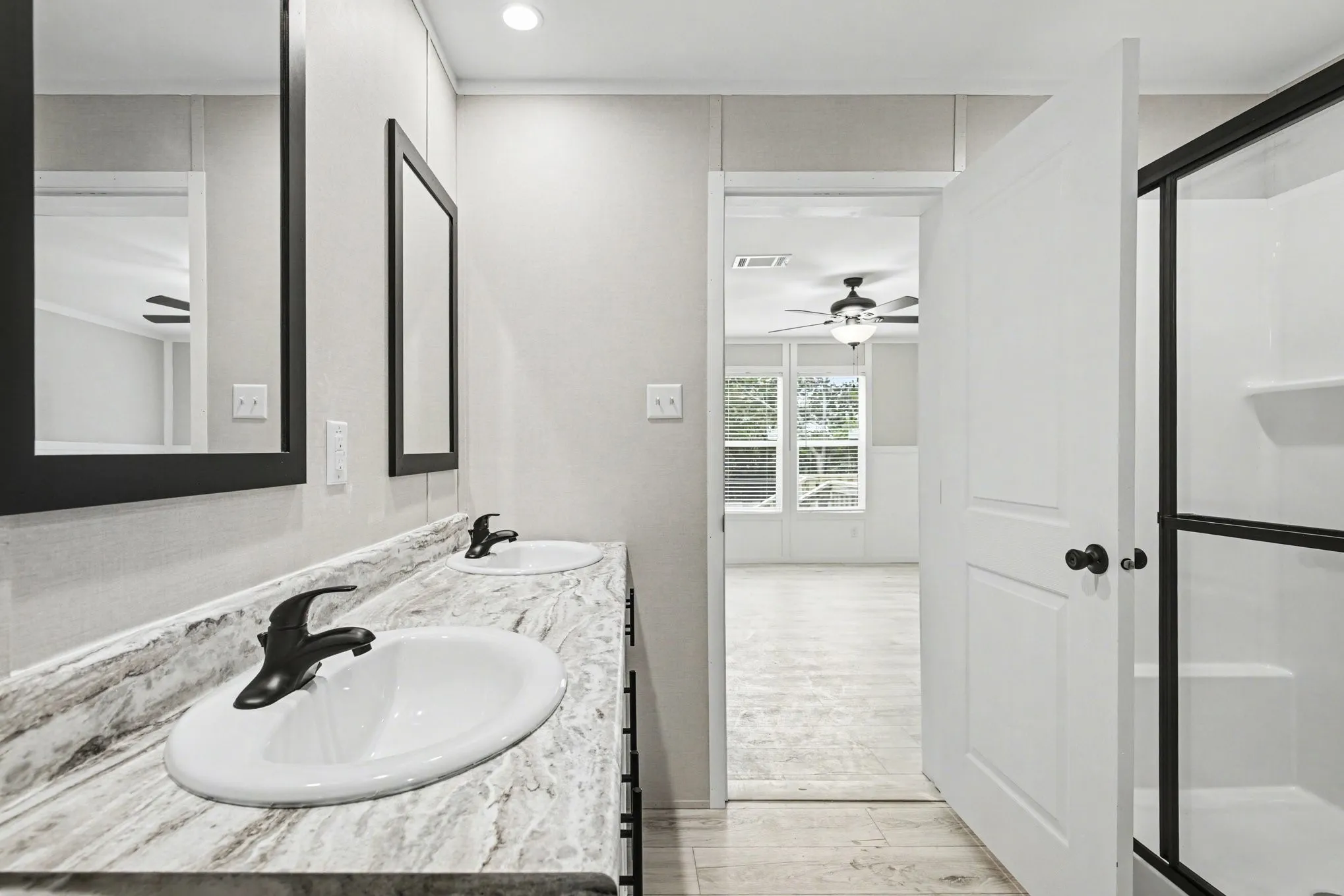 Primary bathroom vanity featuring dual oval sinks with matte black faucets, .