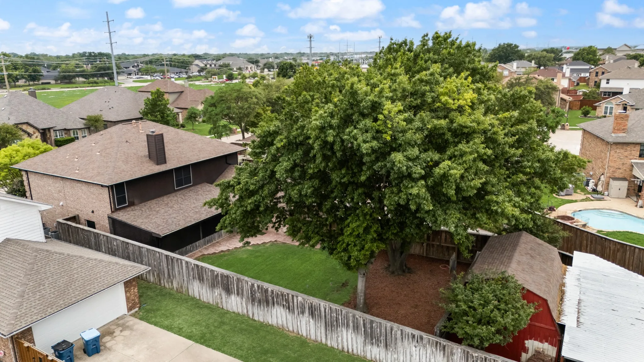 Backyard view showing the two story workshop and carport cover.