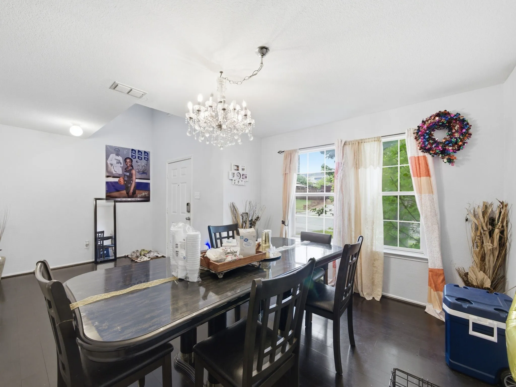 Dining area featuring dark wood-finish flooring and a crystal chandelier