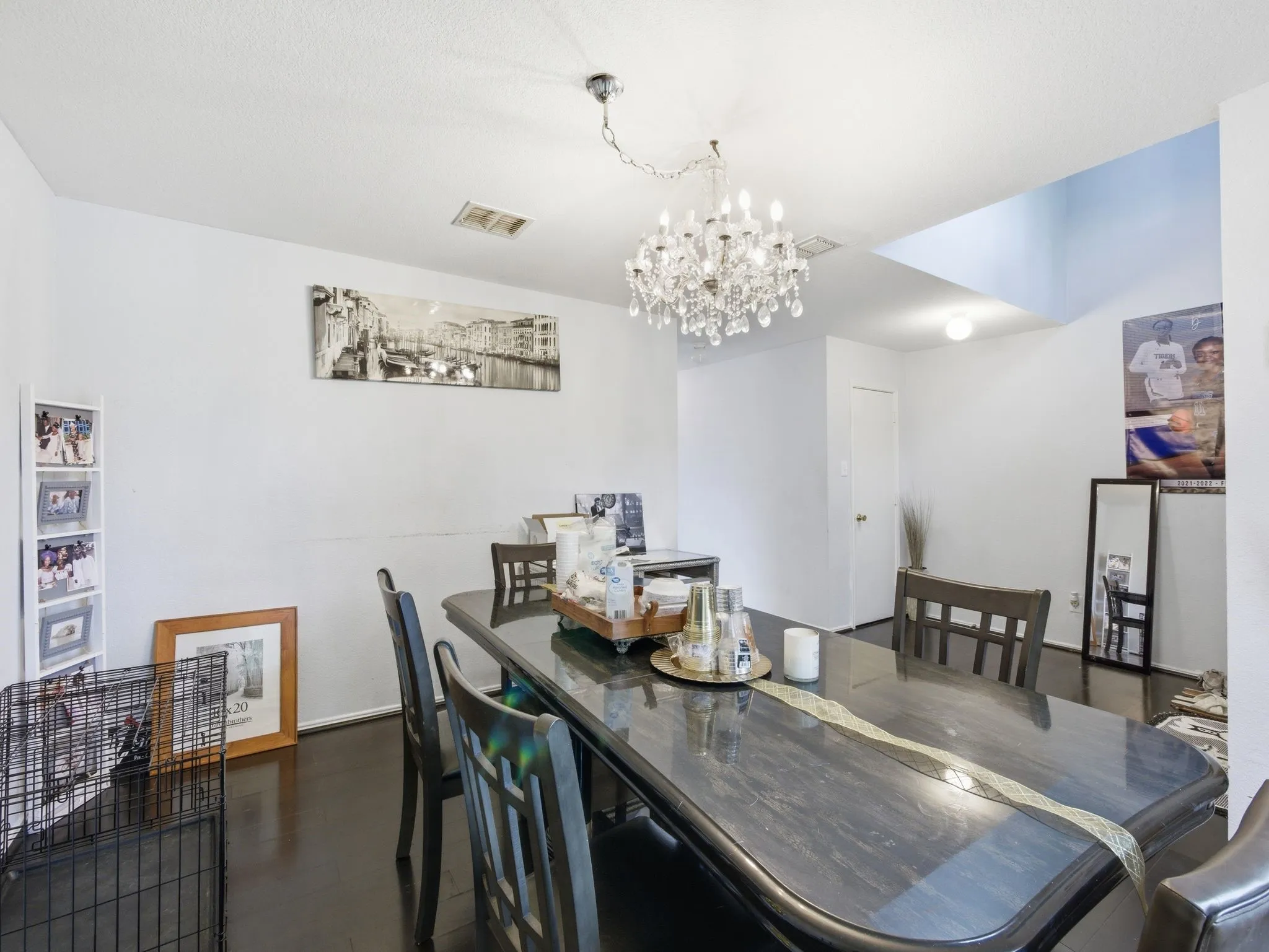 Dining area with a crystal chandelier, dark wood-finish flooring, and white walls