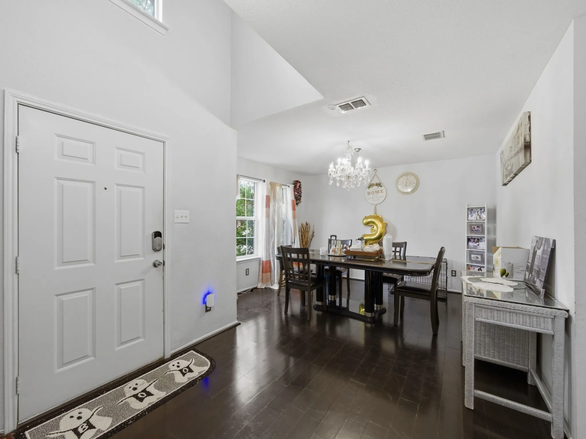 Entry foyer featuring a vaulted ceiling and wood-finish flooring