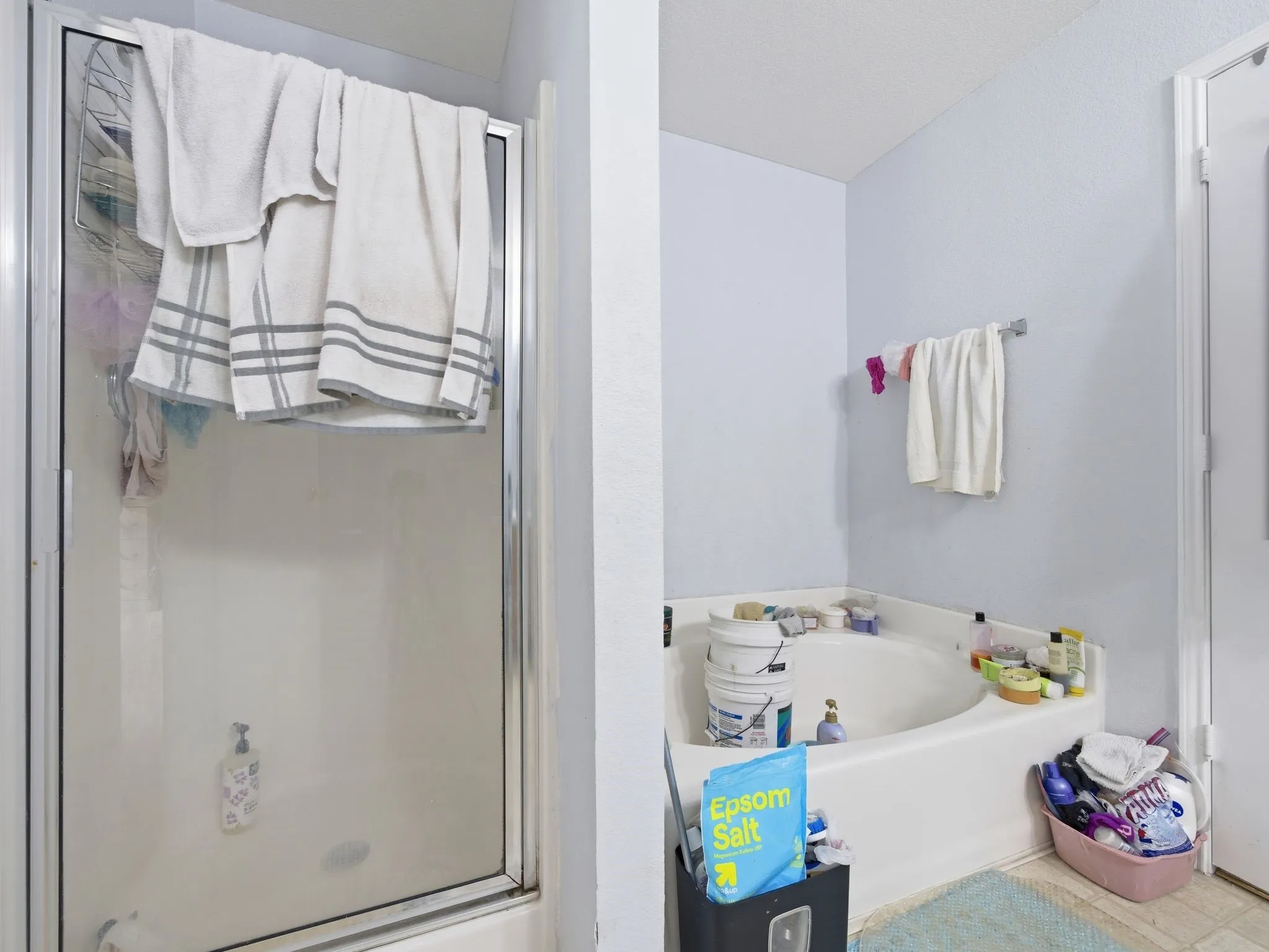 Corner soaking tub with a shower enclosure featuring a glass door