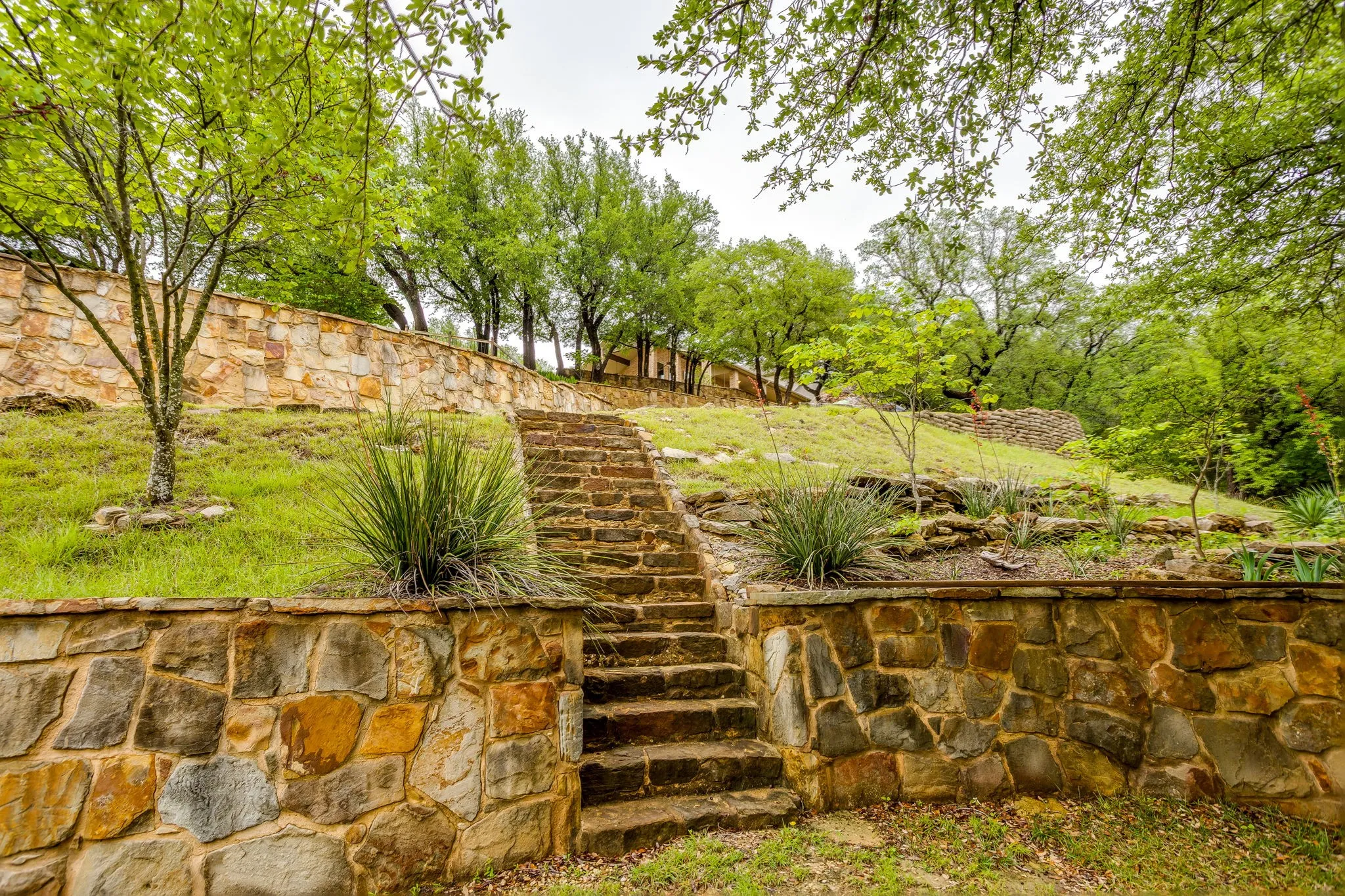 Terraced landscaping featuring natural stone retaining walls and a stone staircase
