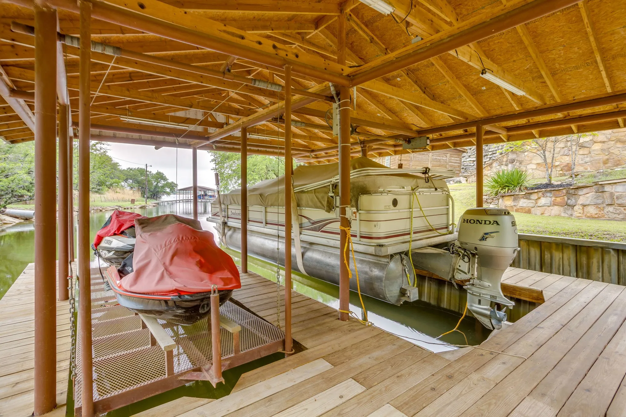 Covered boat dock featuring two boat slips with built-in lifts