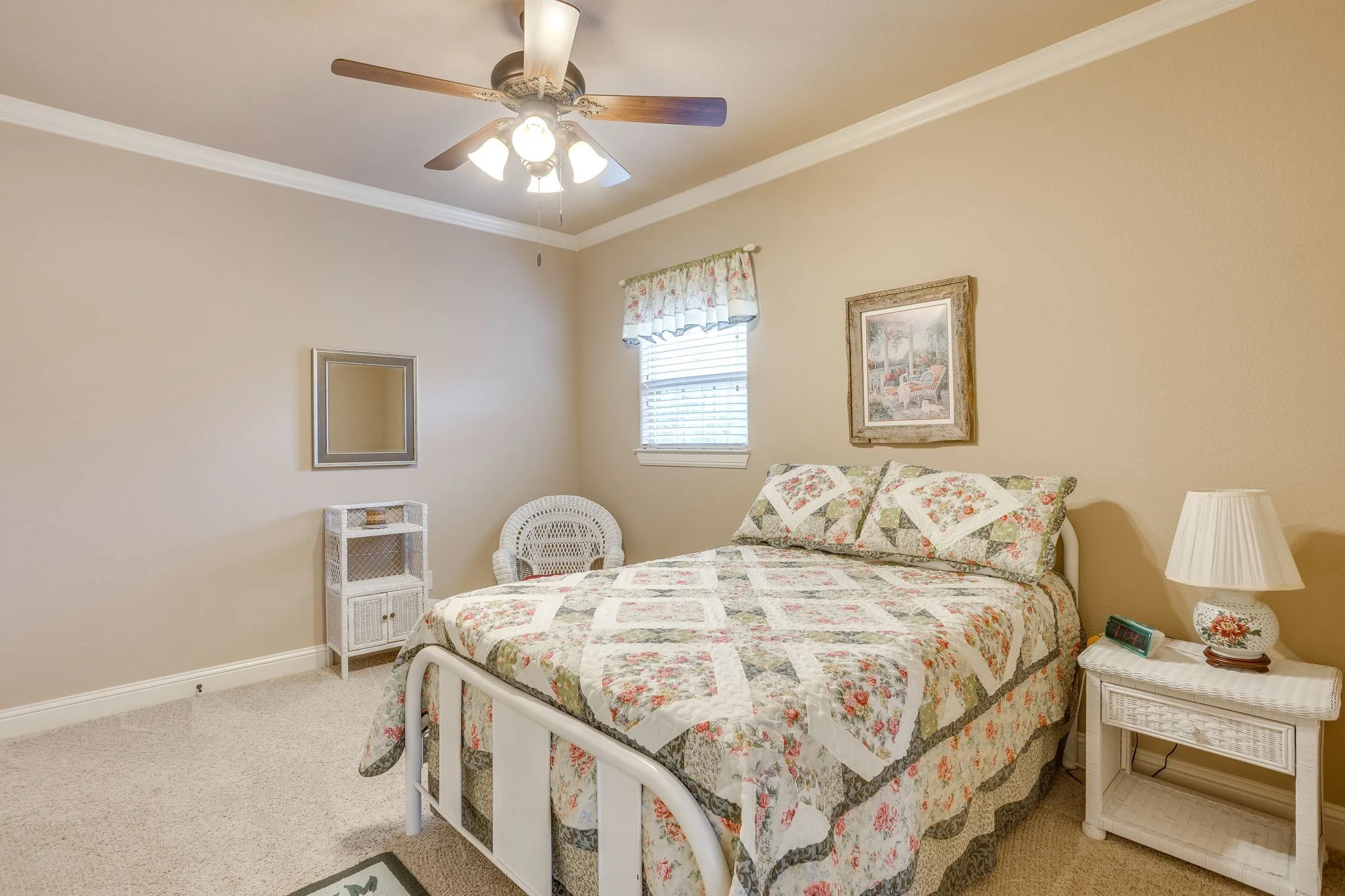 Carpeted bedroom featuring a ceiling fan with integrated lighting, crown molding, and a window with blinds