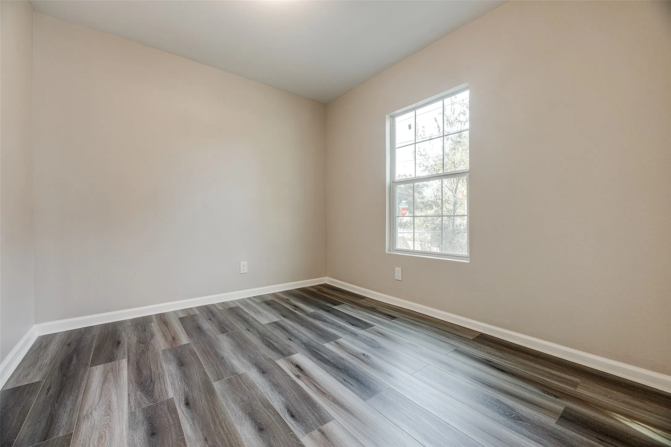 Unfurnished room featuring baseboards and dark wood-type flooring