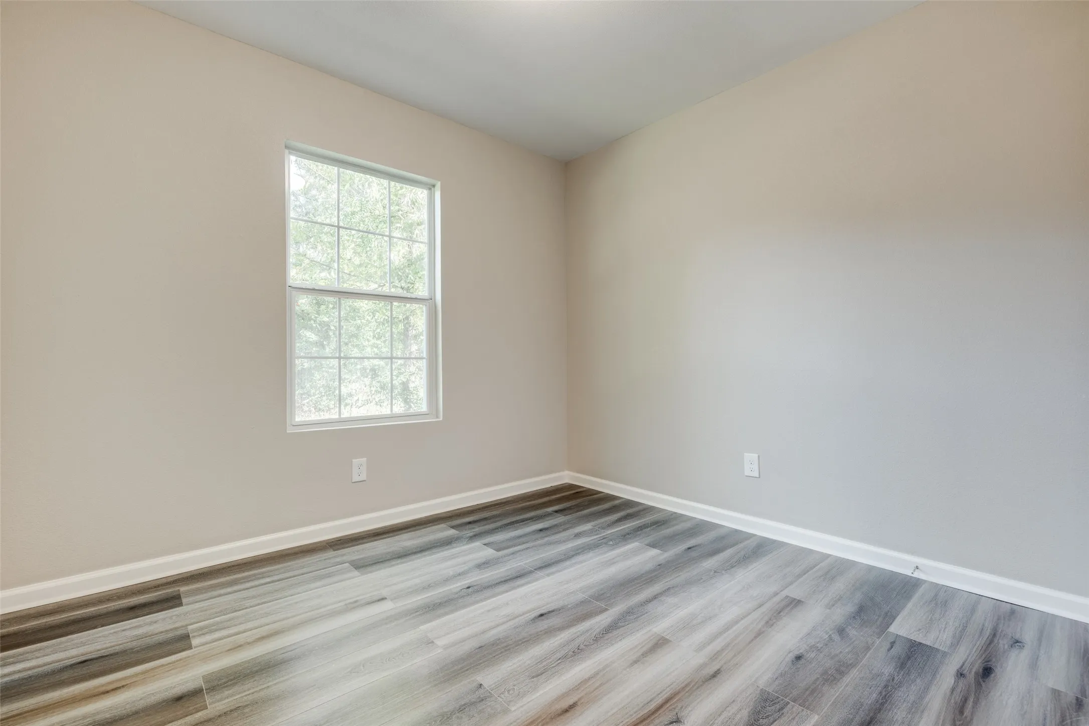 Unfurnished room featuring wood finished floors and baseboards