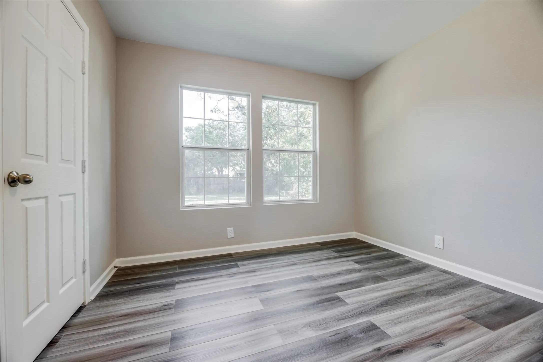 Unfurnished room with wood finished floors and baseboards