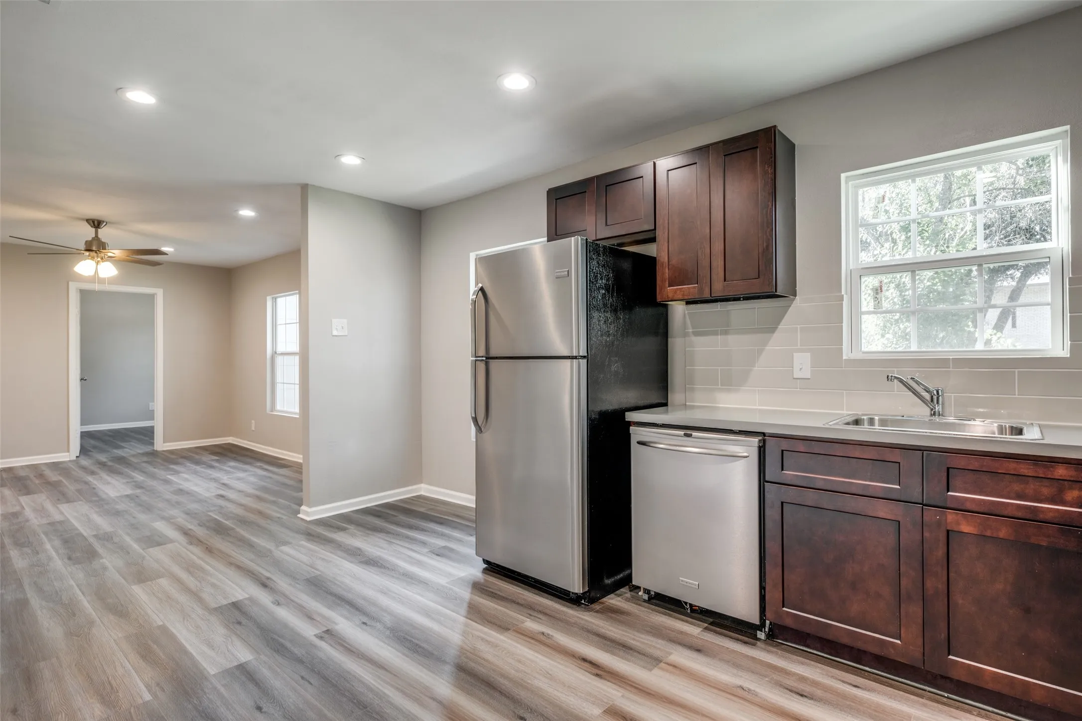 Kitchen with backsplash, appliances with stainless steel finishes, recessed lighting, light wood-style floors, and light countertops