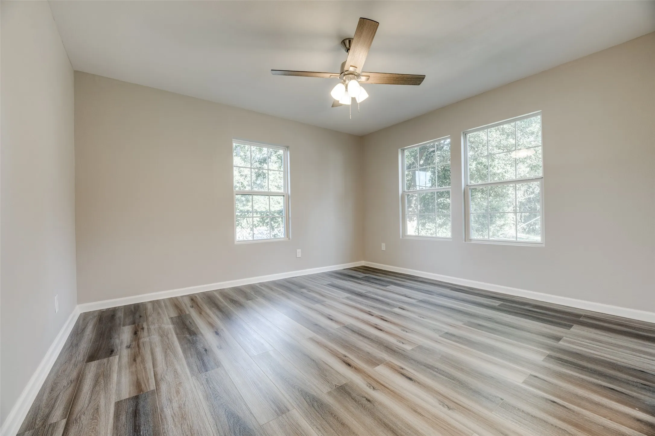 Empty room with wood finished floors and ceiling fan