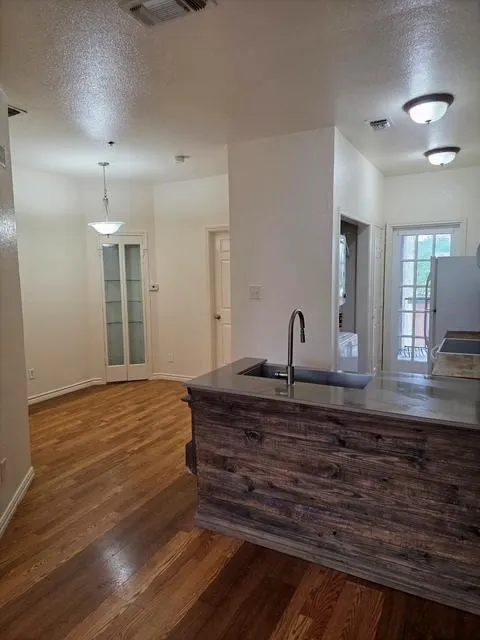 Kitchen island with wood-finish paneling, an undermount sink, and a single-handle faucet