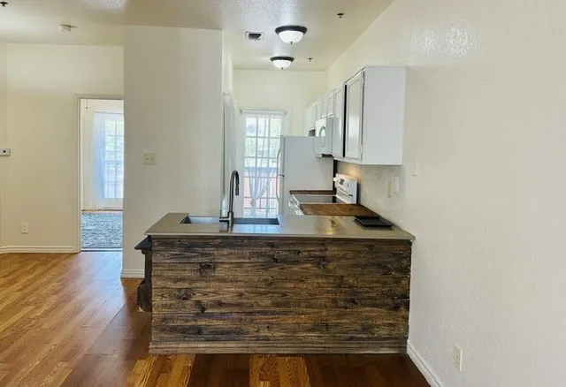 Kitchen featuring a reclaimed wood-look island with an undermount sink and a gooseneck faucet