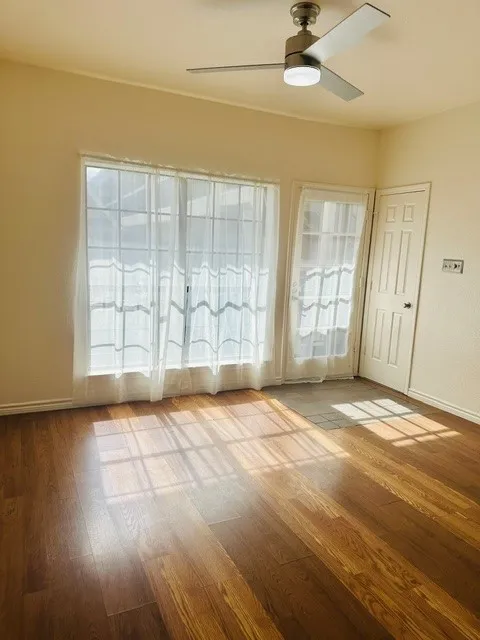 Wood-finish flooring throughout, featuring a modern ceiling fan with integrated lighting
