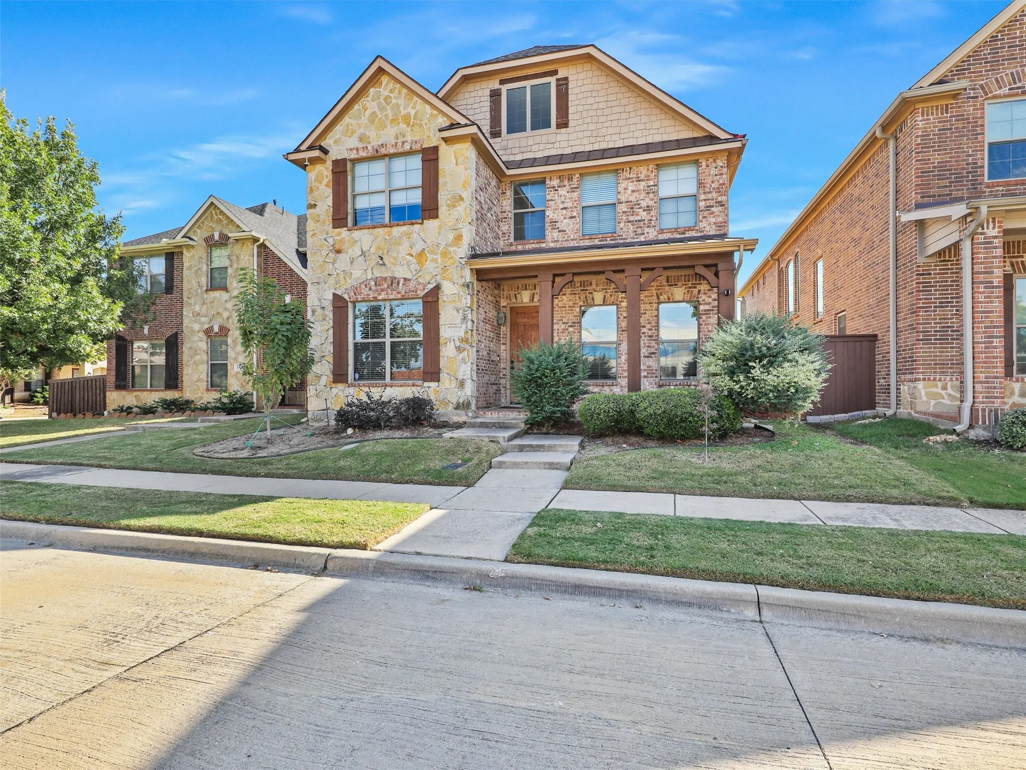 Two-story residence featuring a stone and brick facade