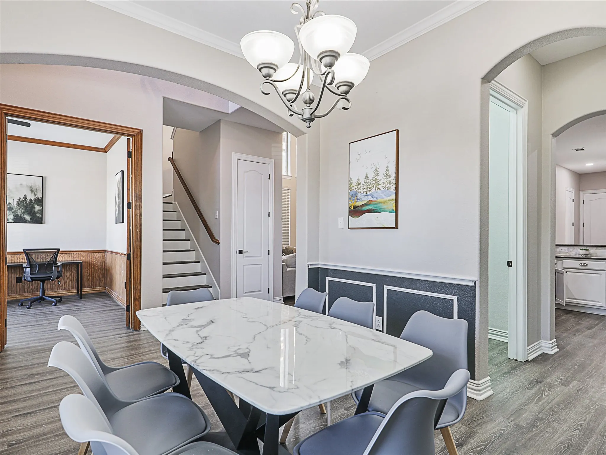 Formal dining area featuring a modern chandelier and wainscoting