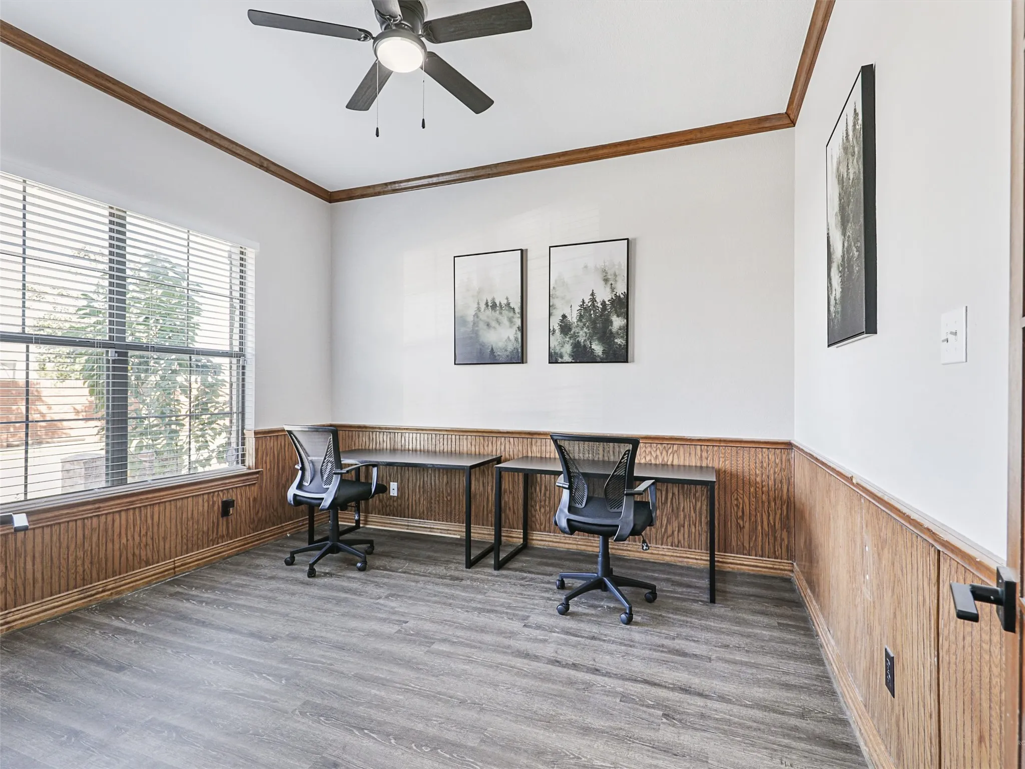 Spacious room featuring wood-finish flooring, white walls, and wood paneling