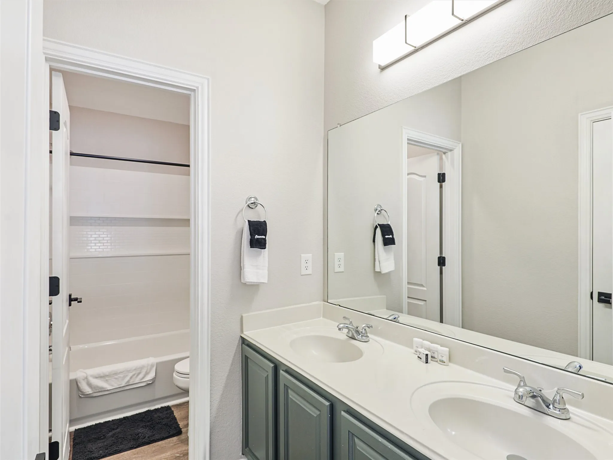 Double vanity with stone-finish countertop, two undermount sinks, and chrome faucets