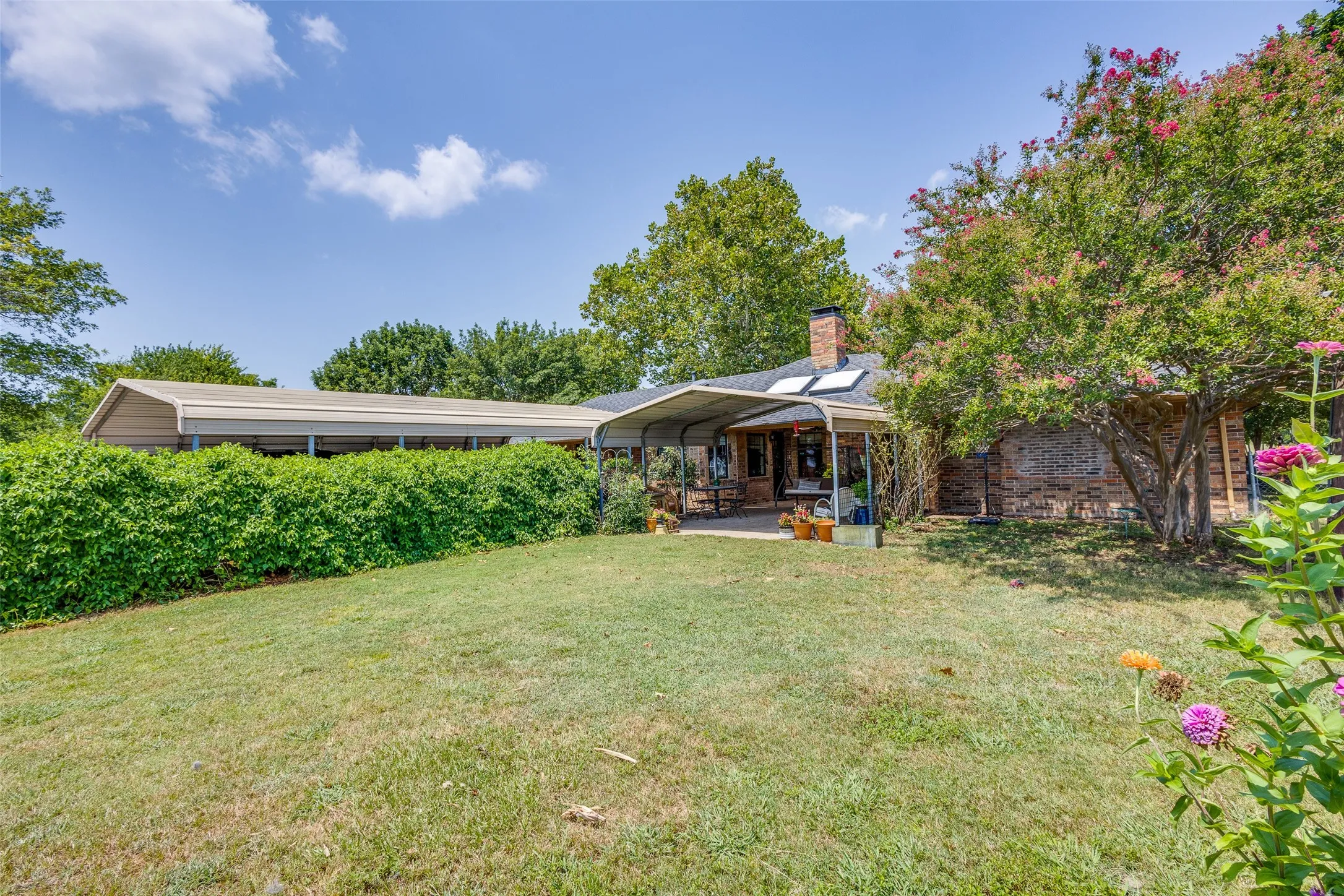 Smaller fenced in backyard area with covered back patio
