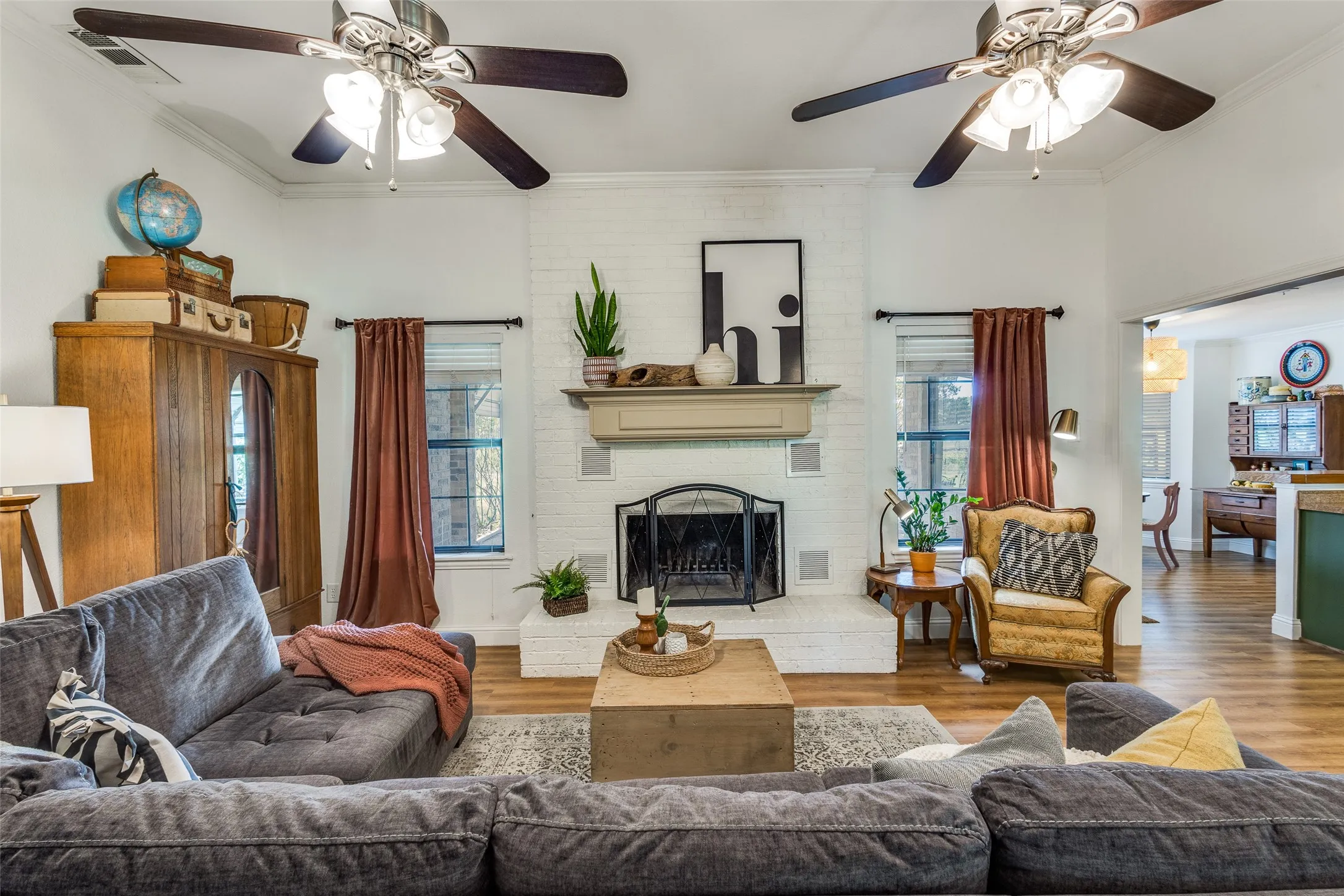 Large living area with a beautiful floor to ceiling fireplace and double ceiling fans