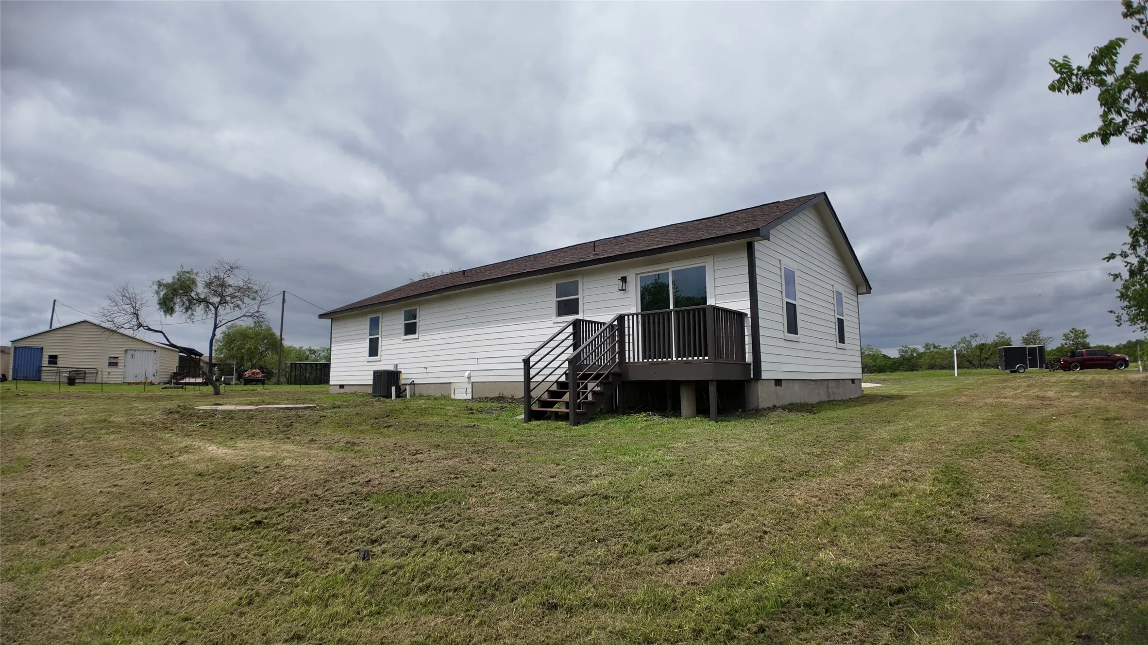 White siding exterior with a brown shingle roof