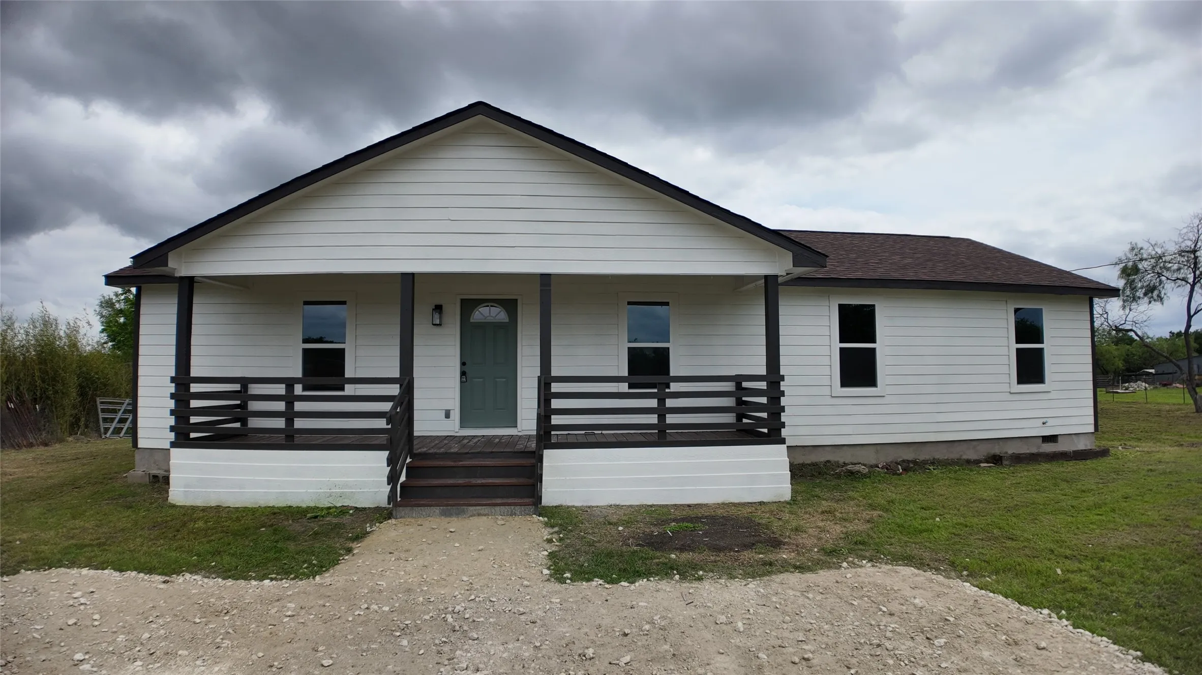 White siding exterior with a dark-trimmed gable roof