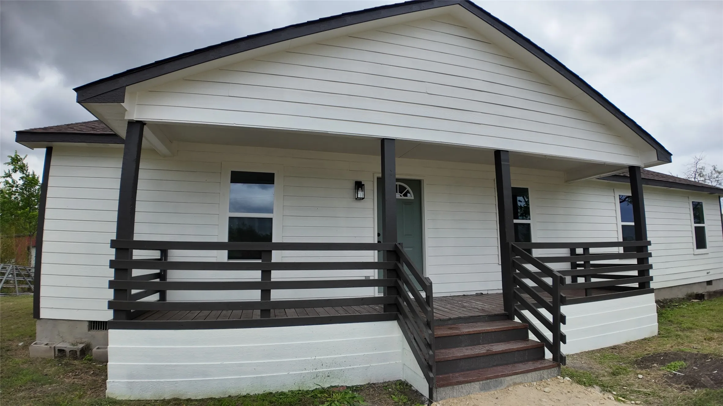 White siding exterior with a dark trim roofline