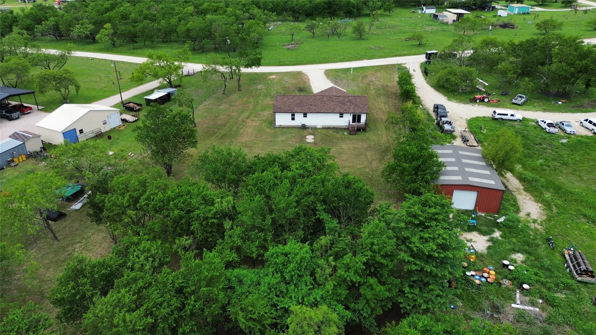 Single-story residence on a sloped lot with a brown shingle roof and white siding