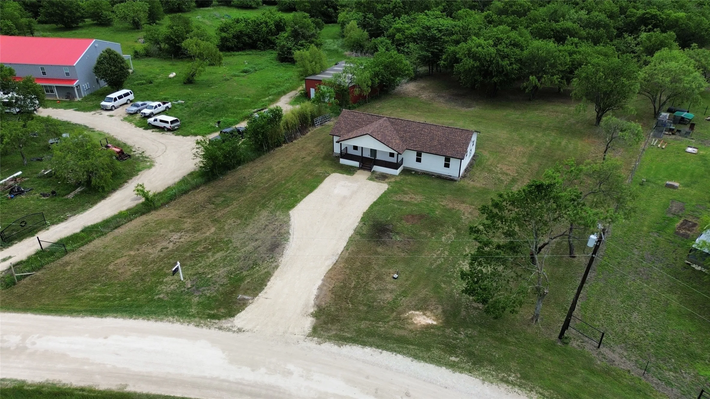 Single-story residence on a spacious lot featuring a brown shingle roof, white siding, and dark trim accents