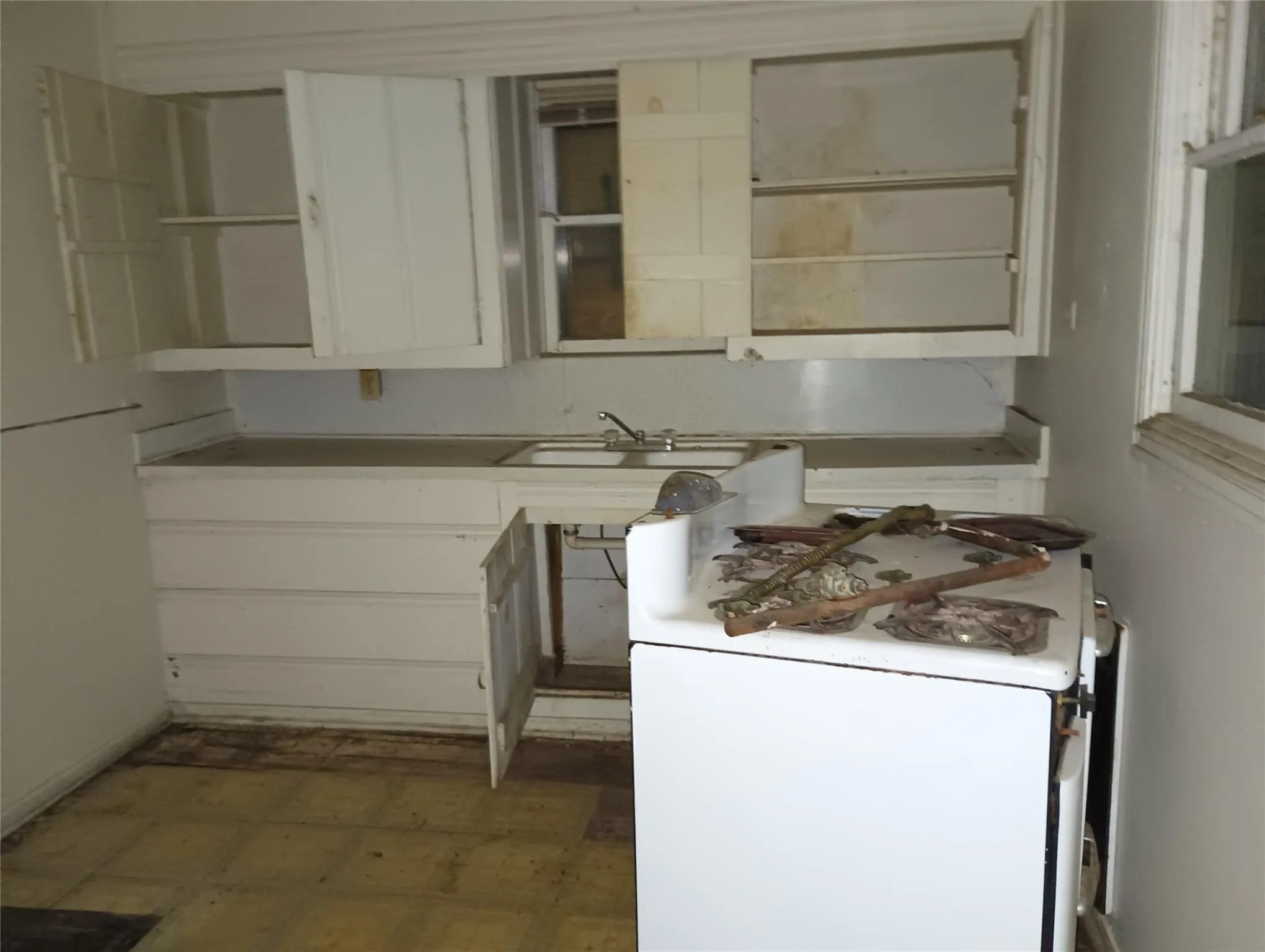 Kitchen area featuring a window, built-in cabinetry, an integrated sink, and tiled flooring