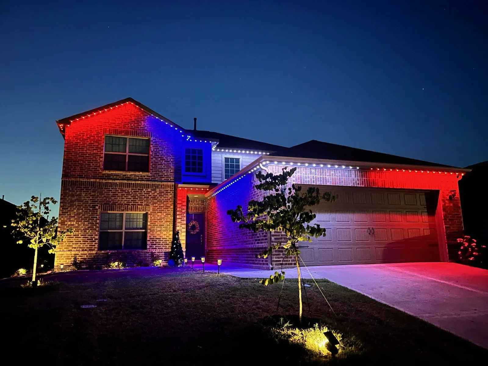 Jelly fish lighting! Two-story residence featuring a brick and siding exterior, an attached two-car garage, and established landscaping