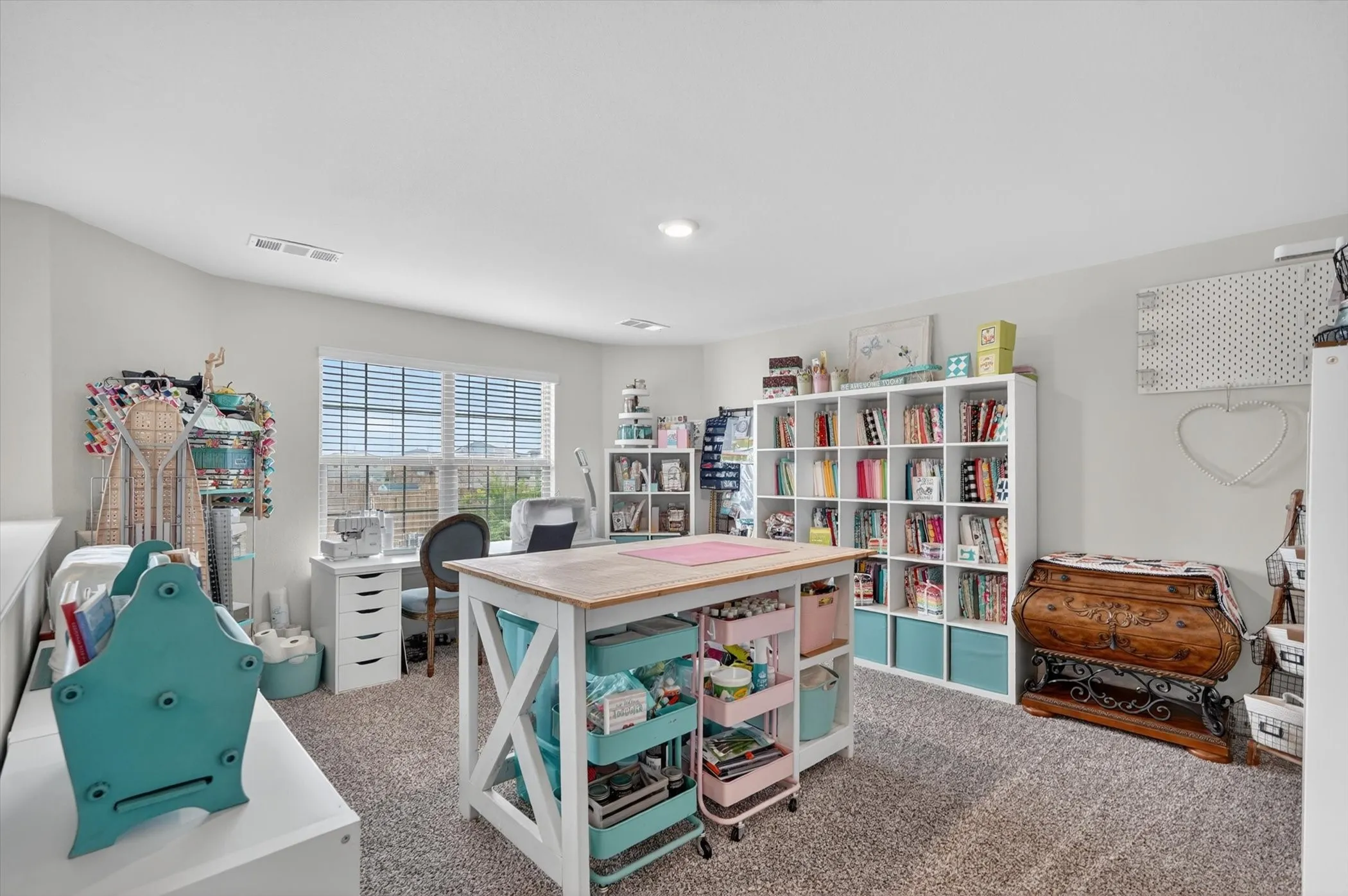 Spacious room with light neutral wall paint, carpet flooring, and a large window with blinds
