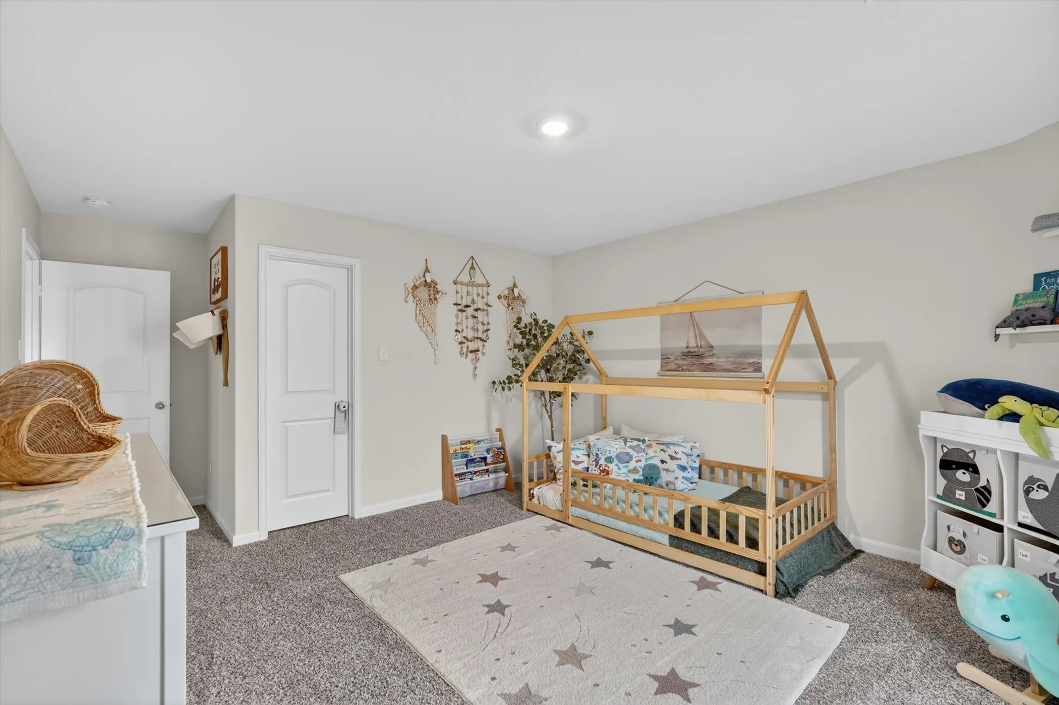 Spacious room featuring neutral wall tones, gray carpeting, recessed lighting, and white two-panel doors