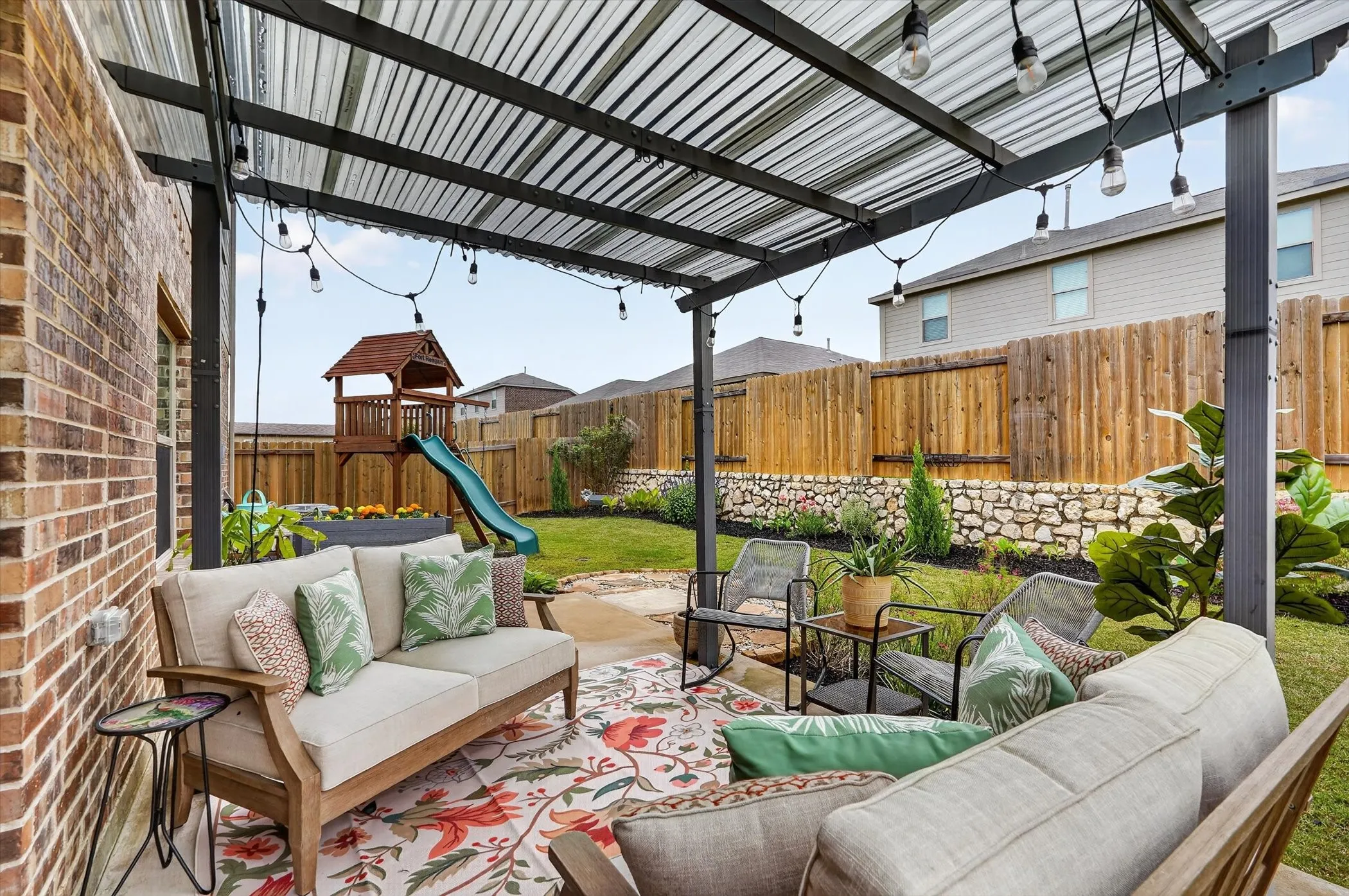 Covered patio featuring a corrugated metal roof and string lighting