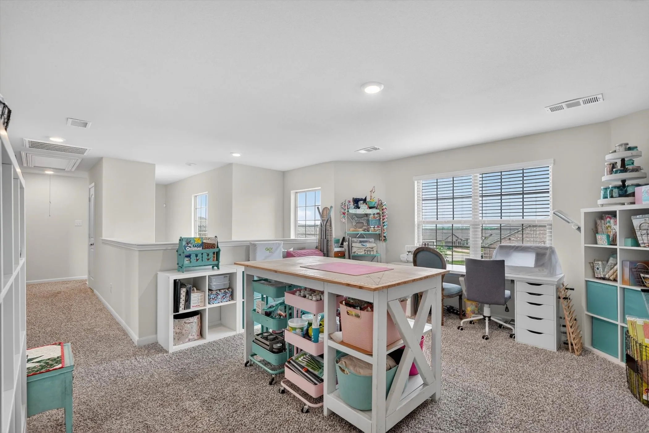 Upper-level flex space featuring neutral carpeting, recessed lighting, and multiple windows with blinds