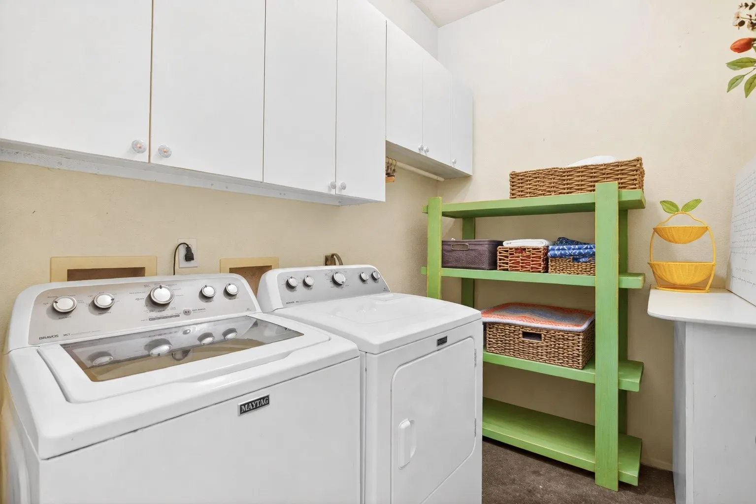 Excellent storage in the laundry room with a built-in shelf, upper cabinets and a hanging rod.