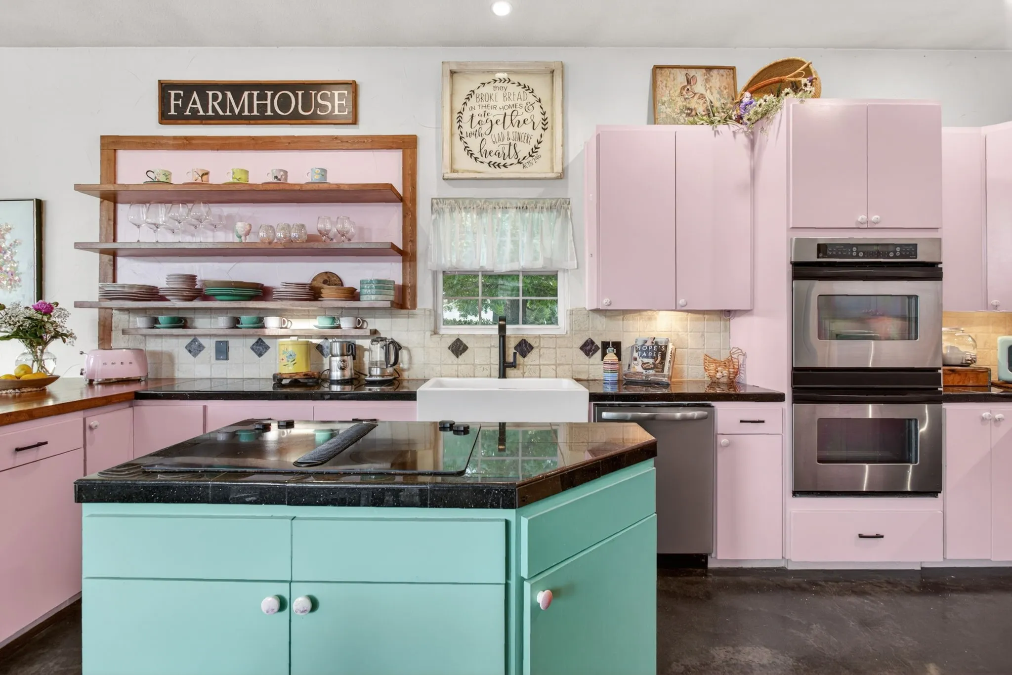 Vintage floral knobs, a true farmhouse sink, custom open shelving and storage galore in this kitchen.