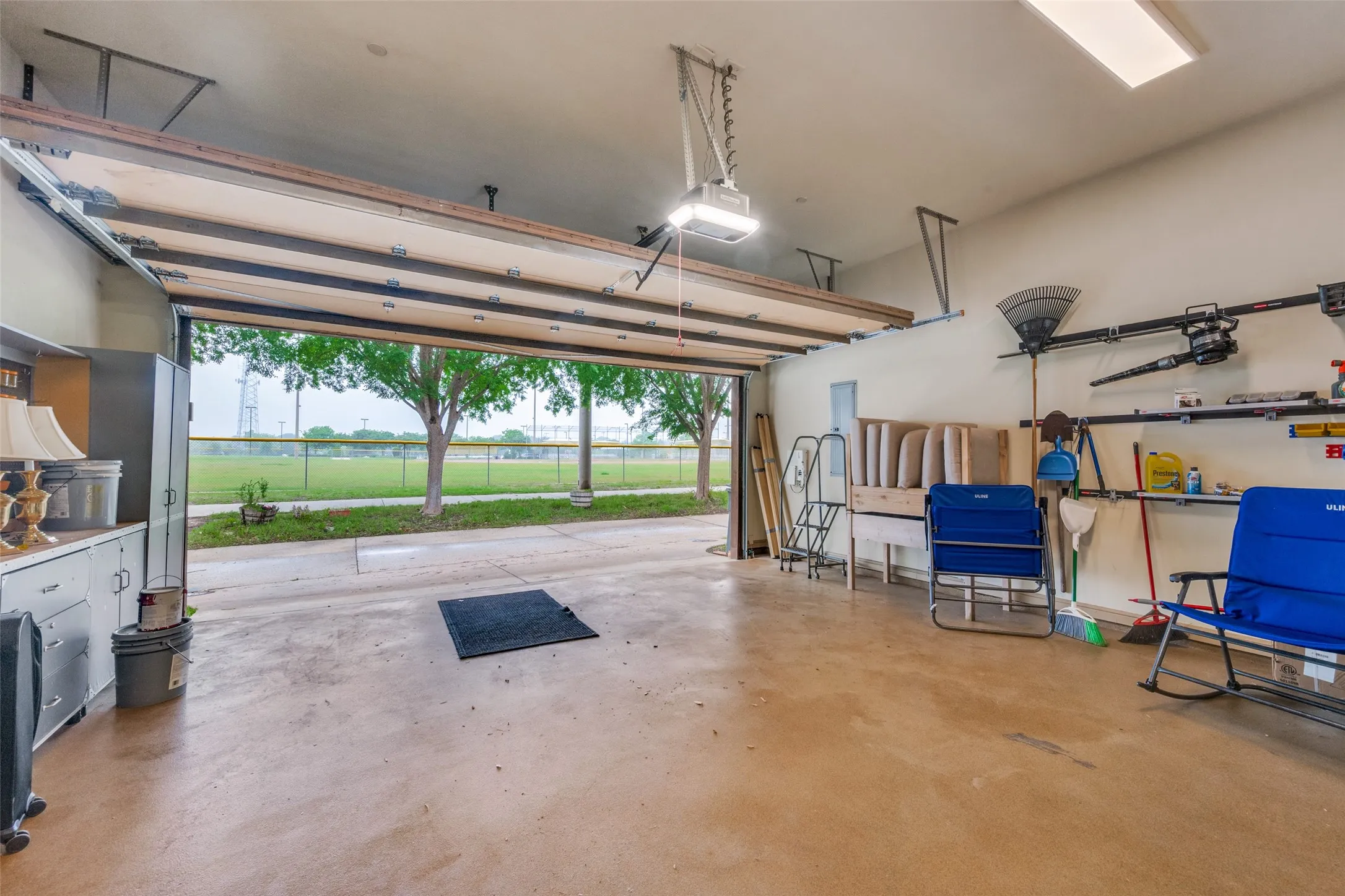 2-Car Garage in Rear Opening to The City Park and Baseball Fields. A rolling staircase for access to extra-tall cabinetry. Rubbermaid FastTrack organization system and built-in workshop, high capacity overhead storage racks and durable epoxy flooring in garage.