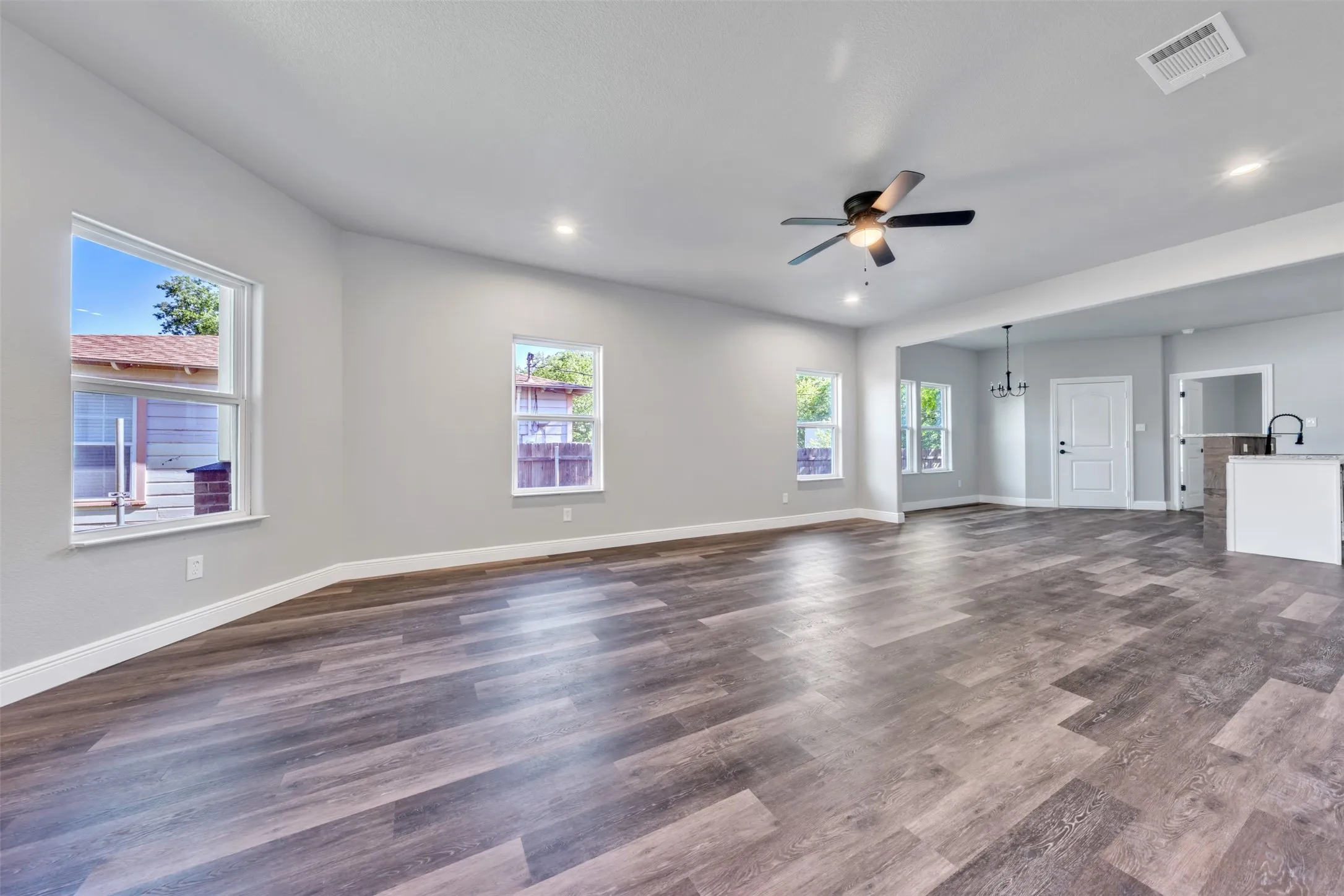 Open-concept living area featuring wood-finish flooring, recessed lighting, and a ceiling fan